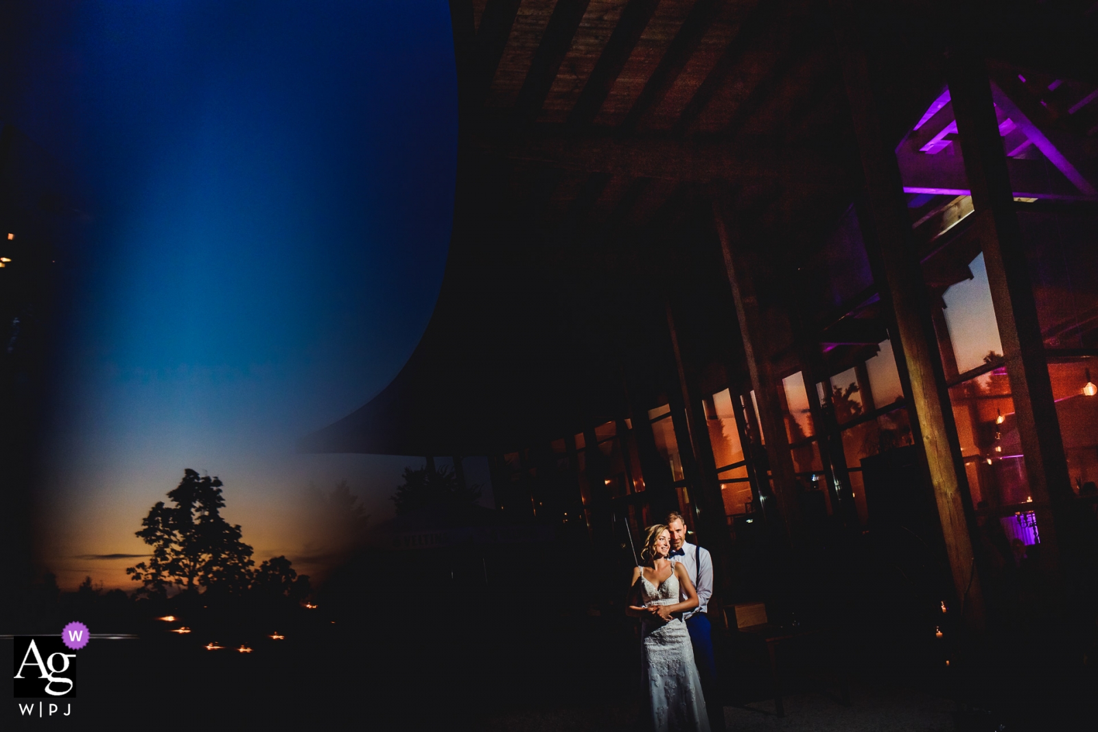 Una pareja de Alemania comparte un abrazo amoroso bajo el cielo del atardecer.