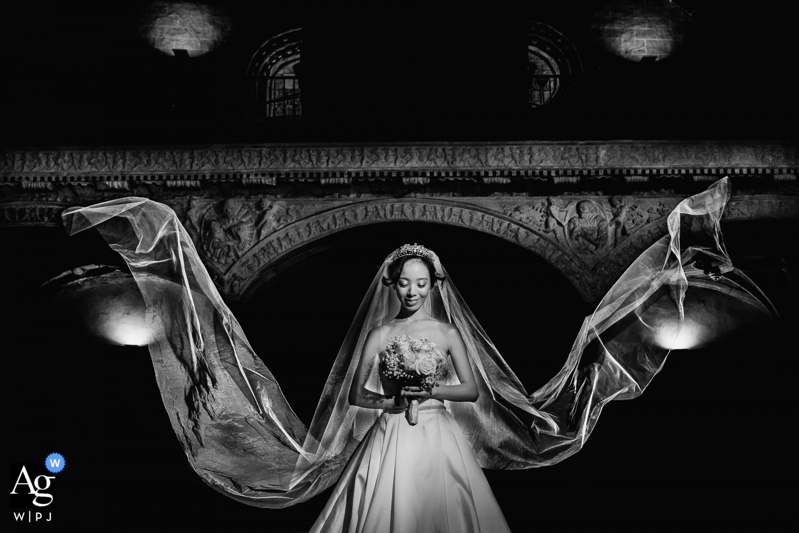 A holy and classic looking wedding image of a bride in Madrid with her veil spread out in both directions. 