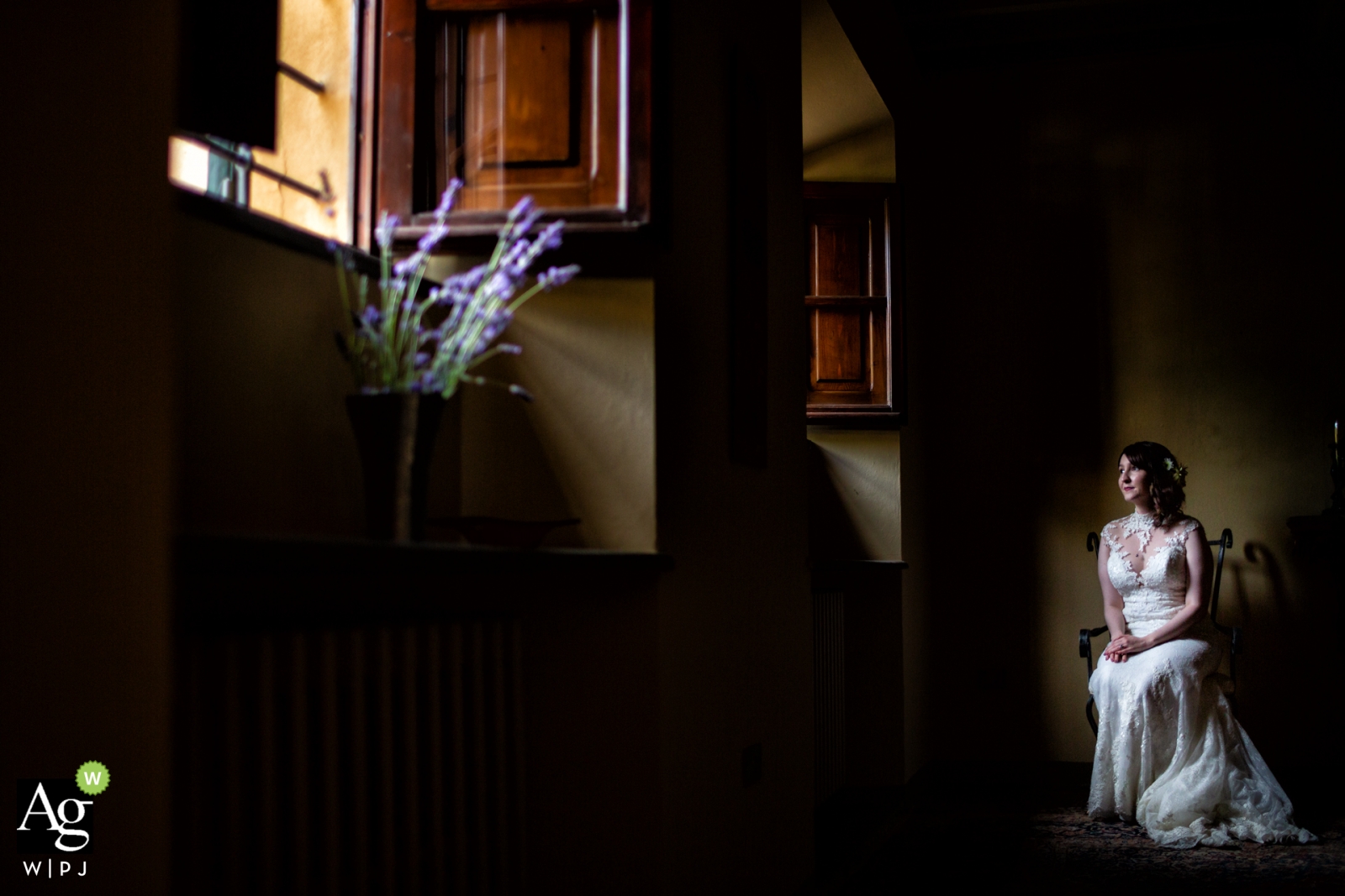 Una novia de Florencia se sienta en el interior esperando el momento en que pueda caminar por el pasillo en una foto de boda en Toscana