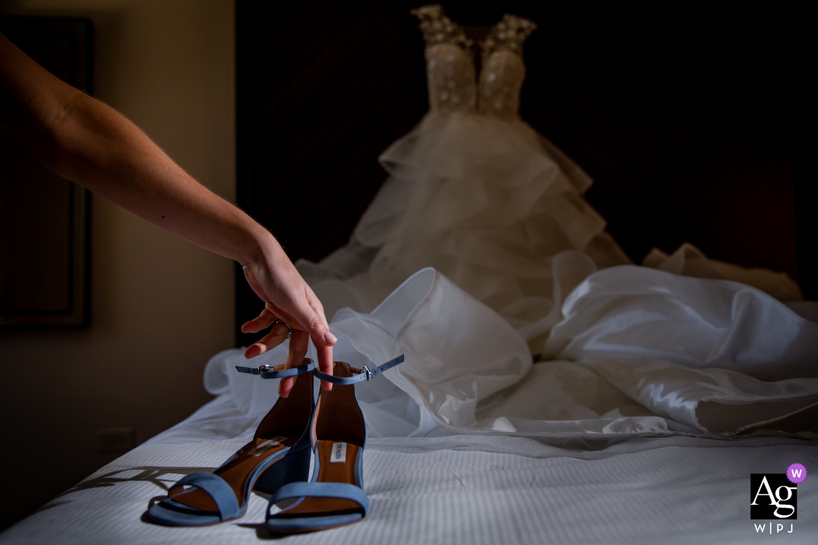 The beautiful Chicago bride carefully placed her shoes on the bed, with her dress seen in the background