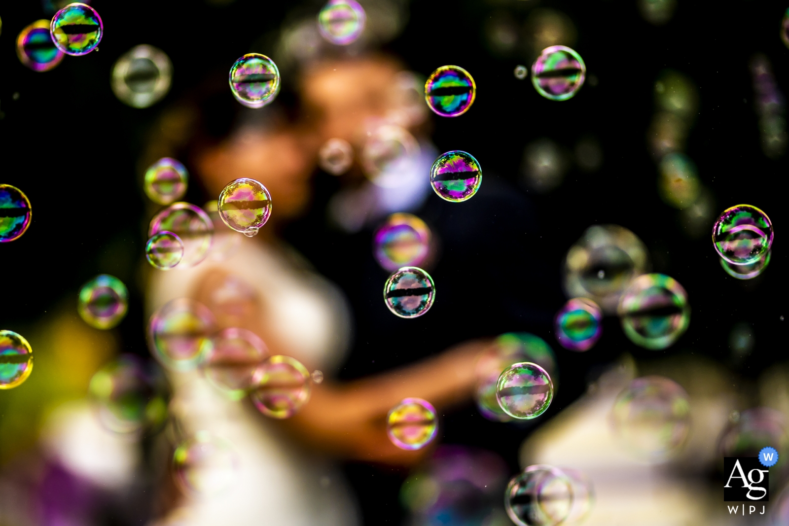 The bride and groom were out of focus in the background, while bubbles filled the foreground of the wedding scene