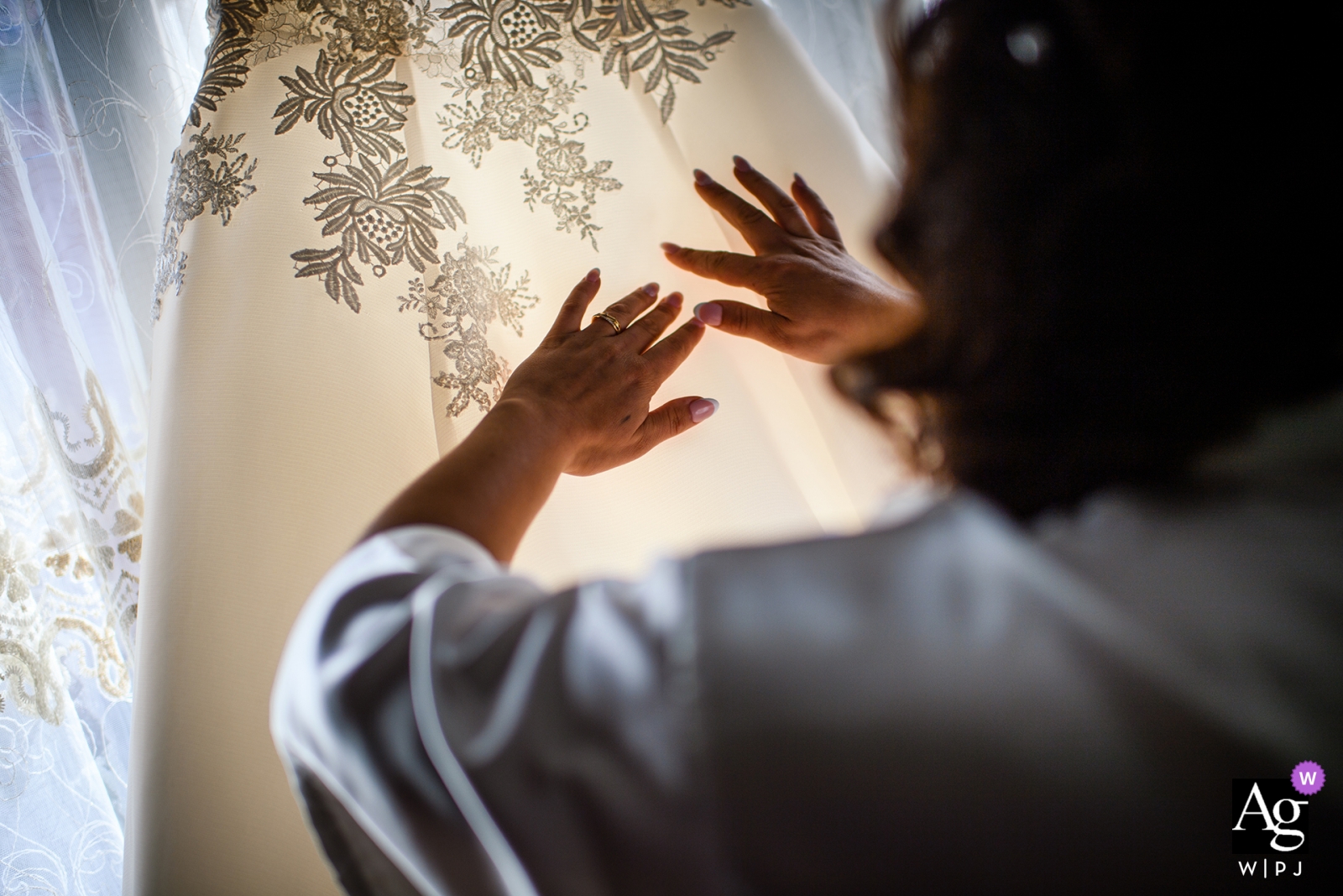 The bride's hands delicately smoothed the hanging dress detail, creating a perfect look for her special day