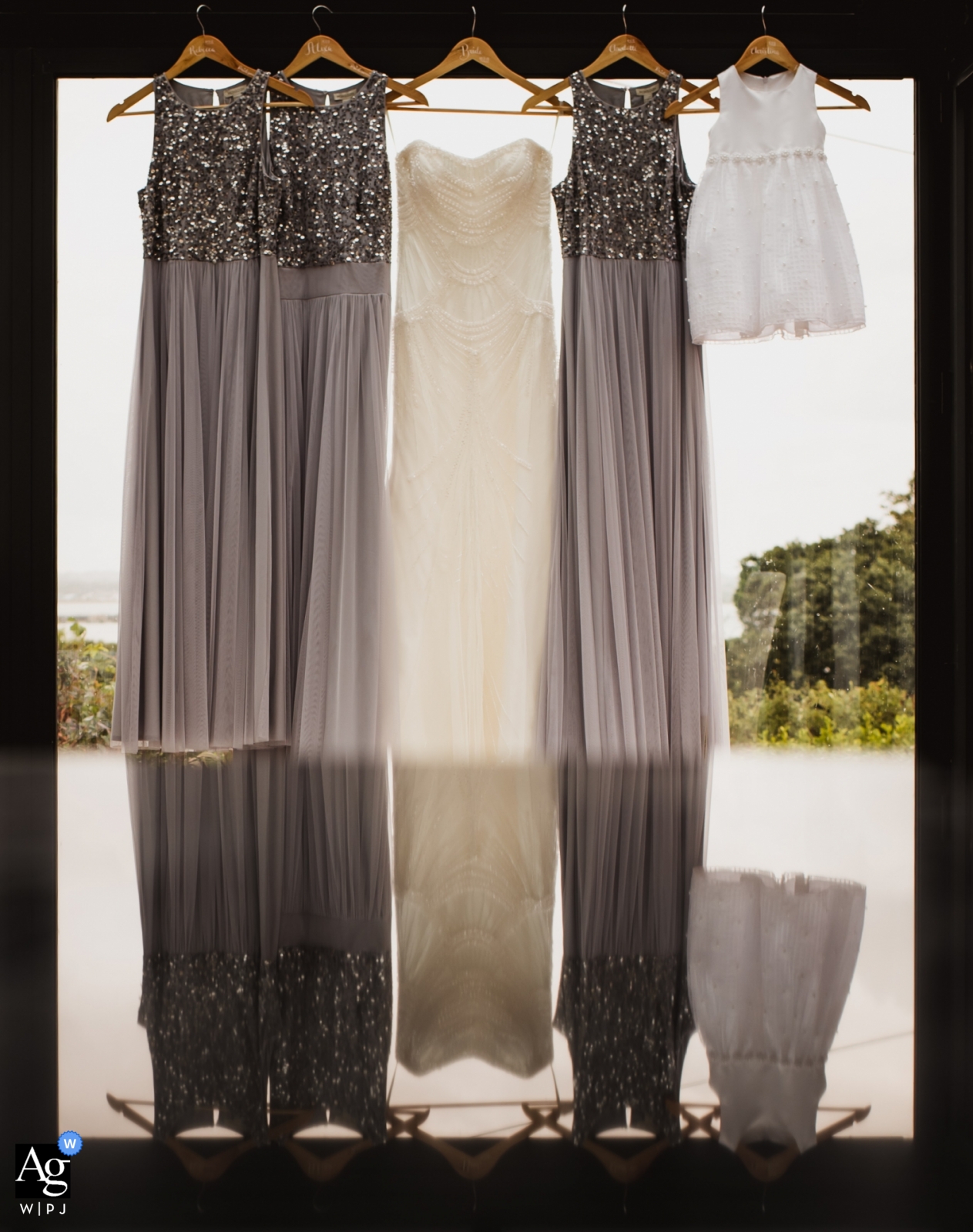 England bridal party dresses handing together in a window before the ceremony