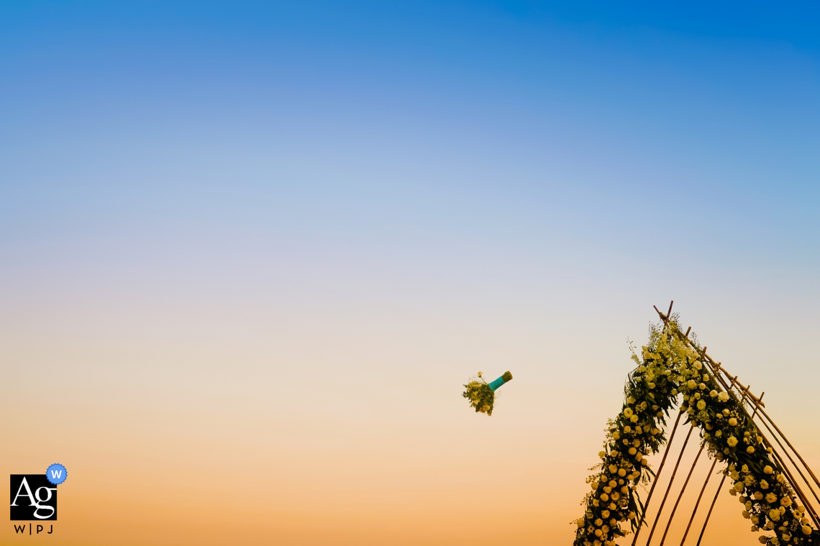 La novia arrojó su ramo de flores con la puesta de sol de fondo en un lugar al aire libre en la ciudad de Ho Chi Minh.