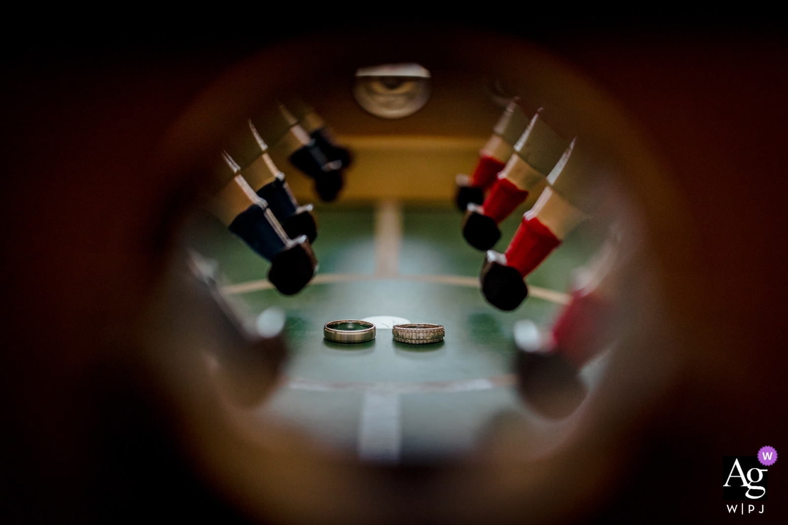 At the wedding in Haute-Garonne, an artistically crafted close-up shot of the wedding rings was taken through the opening of a foosball table