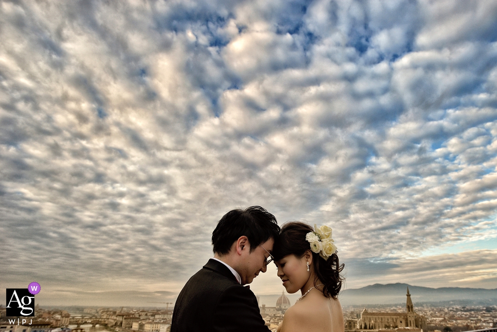 A photo of a bride and groom taken beneath a magnificent cloudy sky at the Hotel La Vedetta in Florence