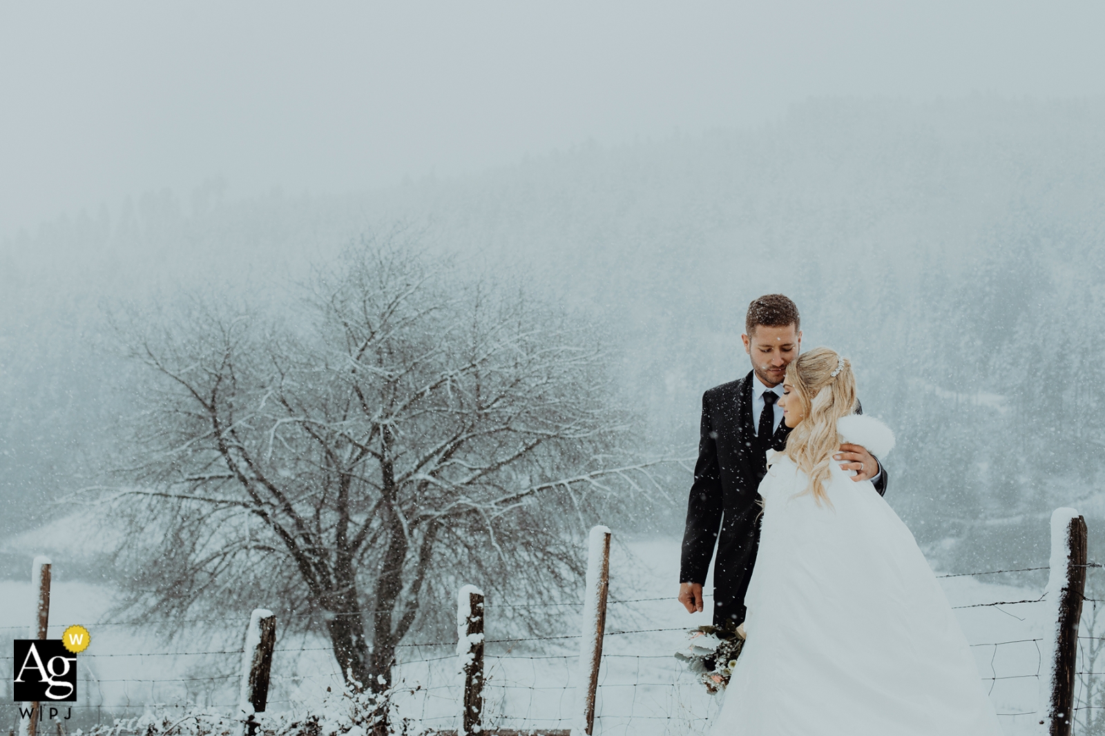 A photo of a tender embracing couple in a winter snow scene near Lyon captures the beauty of the scene