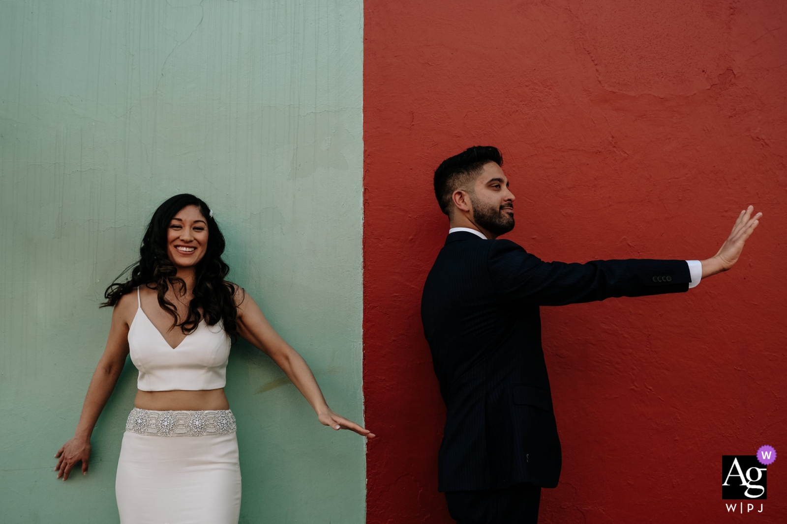 Una pareja en la ciudad de Oaxaca, México, posan felizmente para un retrato frente a una pared pintada con audacia.