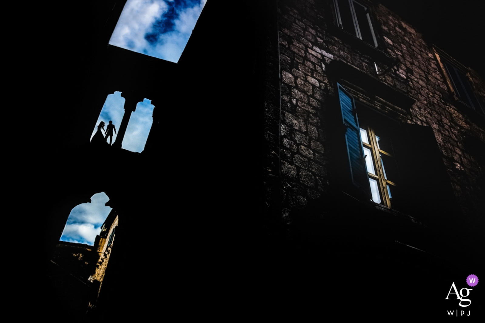 Un couple de mariés du Monténégro a été photographié dans les fenêtres du château de Kotor contre un ciel bleu brillant