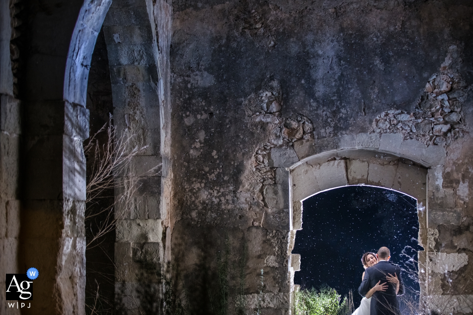 A romantic wedding portrait was taken of a couple at the ruins of Cassibile, Sicily framed by a door arch