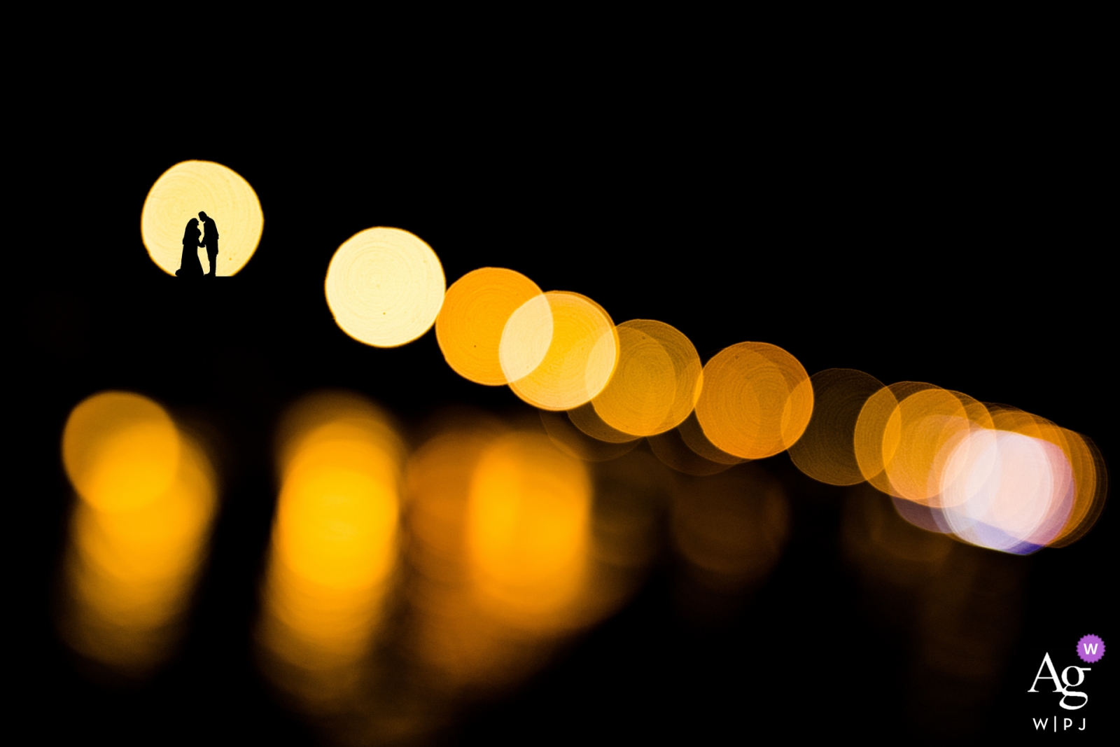 Un beau portrait de couple en silhouette a été créé pour un jour de mariage à Syracuse, en Italie, avec un éclairage ponctuel et des cercles de bokeh chauds