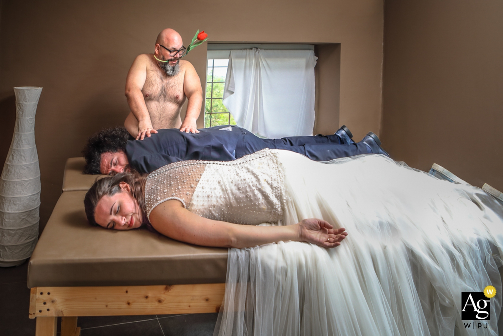 Em Siracusa, na Itália, uma imagem profissional foi tirada no dia do casamento, mostrando um casal relaxado recebendo massagens separadas com uma massagista cuidando das costas do noivo.