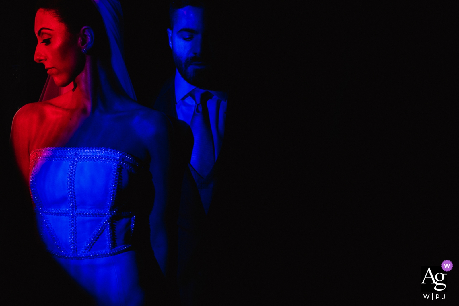Photo by: <a href="https://www.wpja.com/photos/artistic-wedding-photographers/2438256">Renan Radici - Porto Alegre Rio Grande do Sul Brasil couple with church stained glass lighting them with red and blue spotlighting