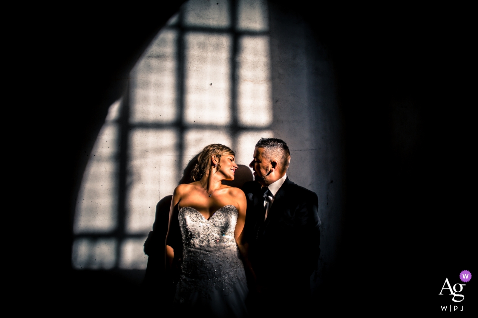 A bride and groom portrait in window shadows was captured in Lucca on a wedding day