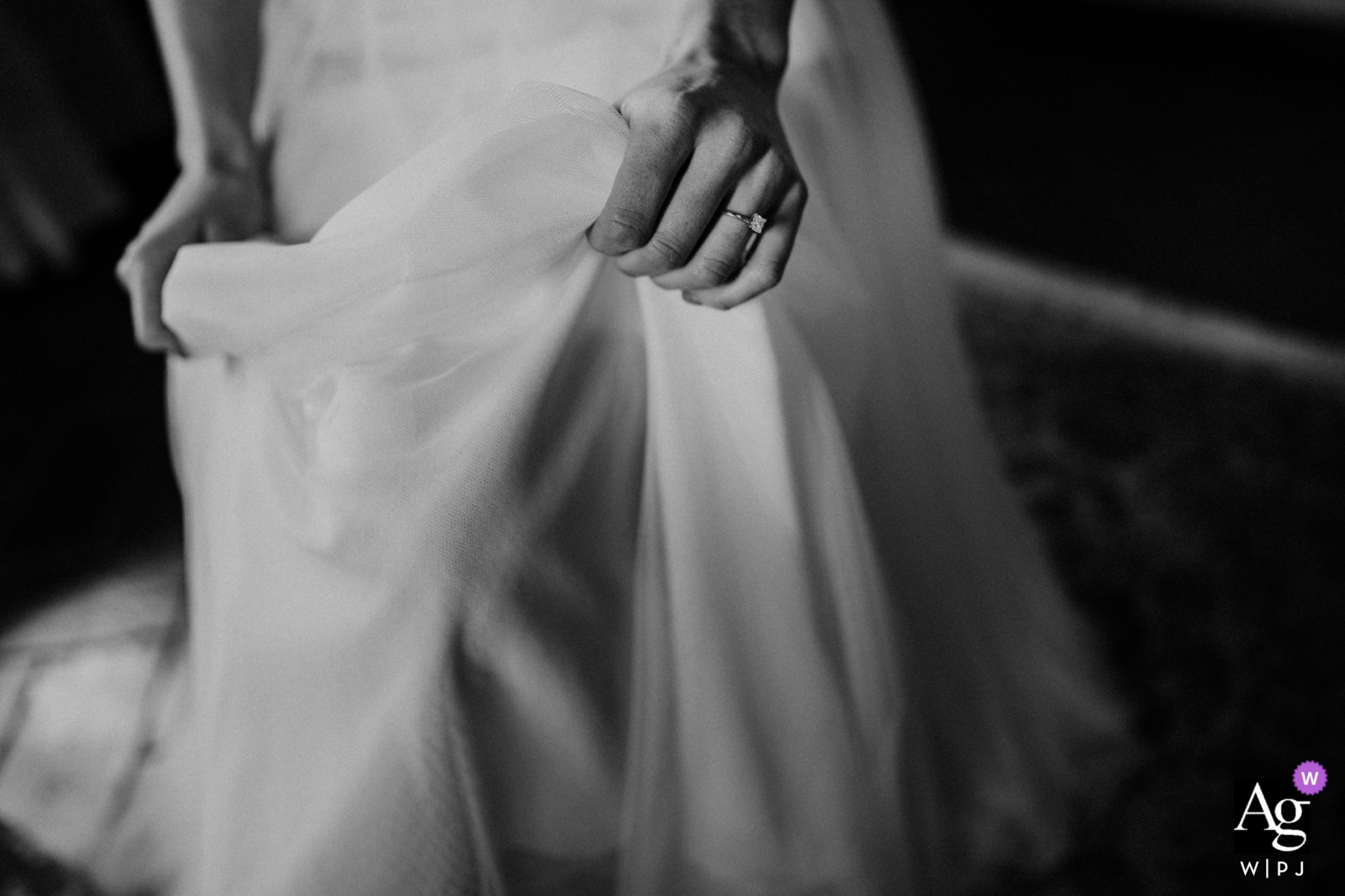 El día de la boda en Agriturismo Pian Di Filetto en Italia, se capturó una hermosa toma en blanco y negro de las manos de la novia sosteniendo su vestido blanco.