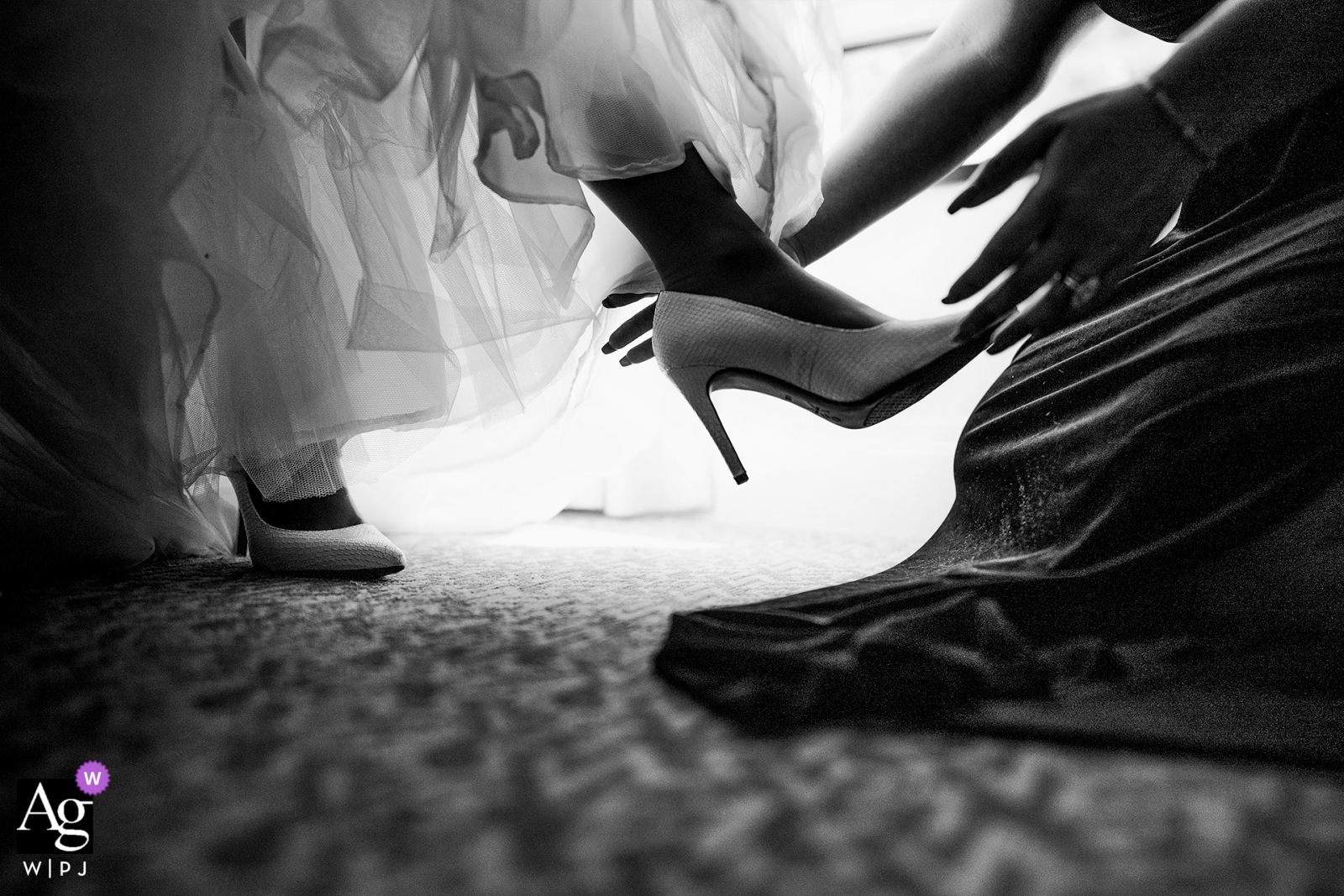 Photo by: <a href="https://www.wpja.com/photos/artistic-wedding-photographers/2440186">Emin Kuliyev - Bronx New York The bride receives help putting on her shoes at the Battery Gardens, New York | artistic wedding photographer