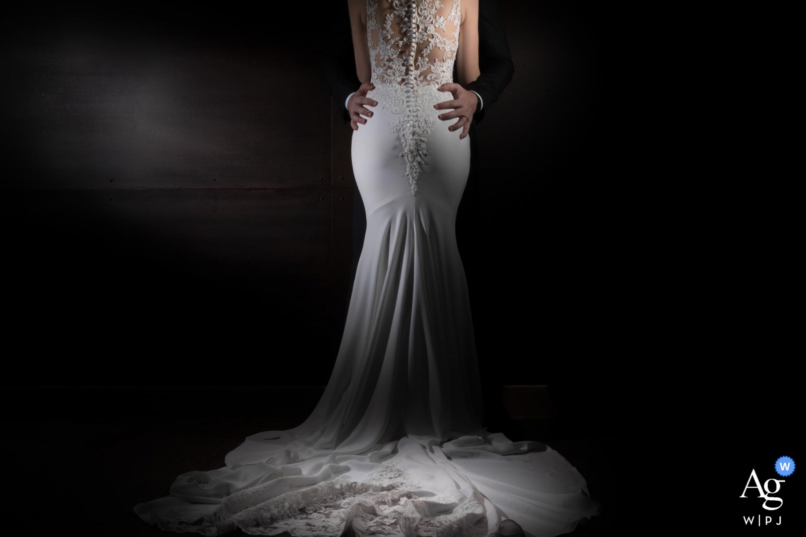 A traditional wedding was captured in a gown detail wedding picture taken at São Caetano do Sul, with the bride's dress detail in the shot and the groom's hands resting on her hips