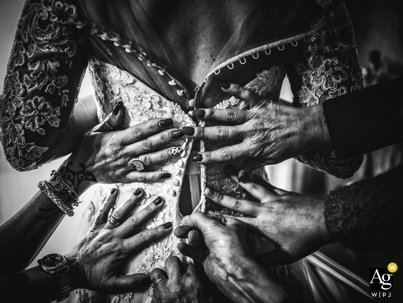 Photo by: <a href="https://www.wpja.com/photos/artistic-wedding-photographers/2442671">Matteo Originale - Bolano La Spezia Firenze wedding day photography | black-and-white detail Image of many hands helping the bride while she is getting ready