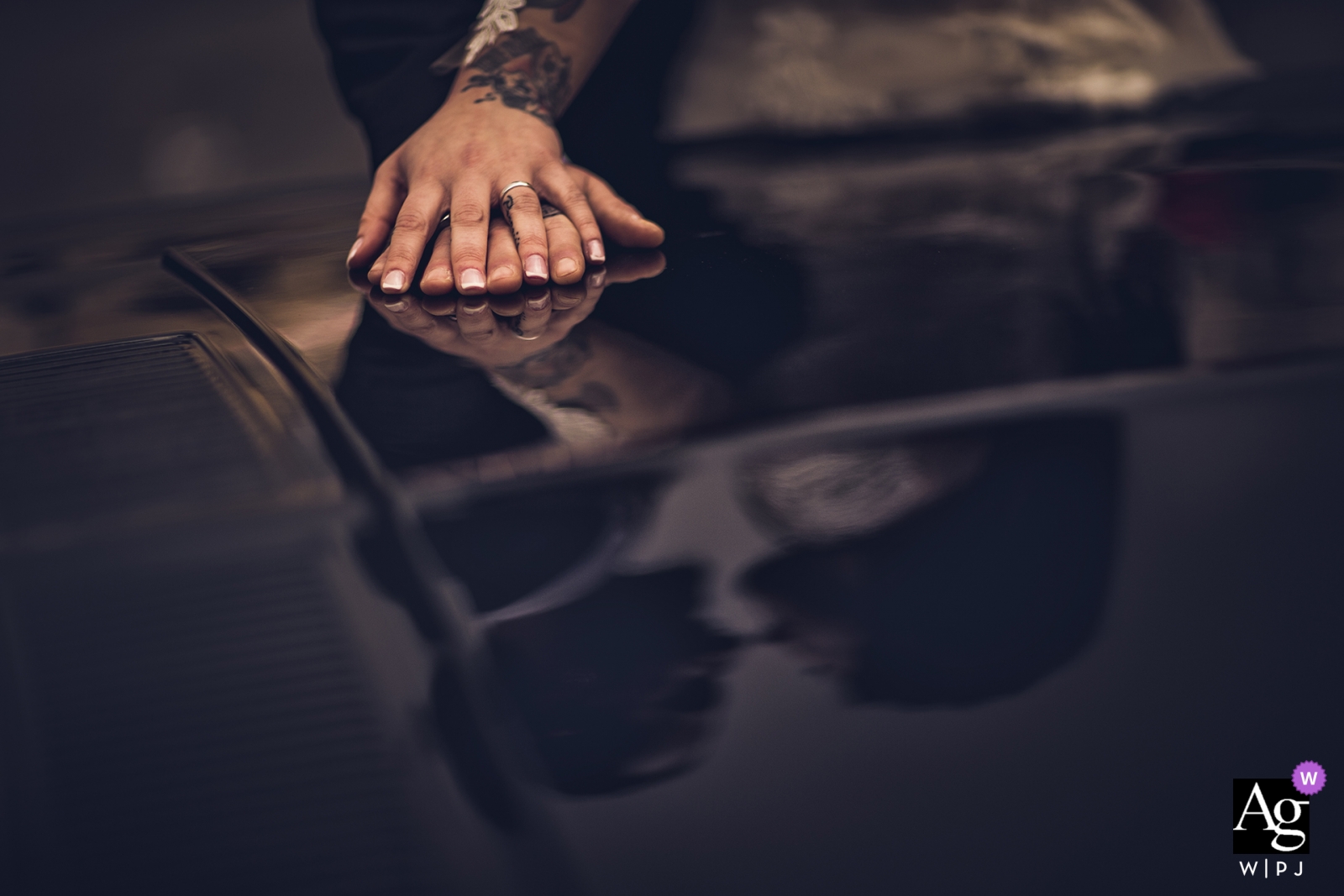 Los recién casados ​​compartieron un abrazo especial en Sarzana, capturando una foto que mostraba los detalles de su amor en el capó reflectante de un automóvil, con las manos juntas.