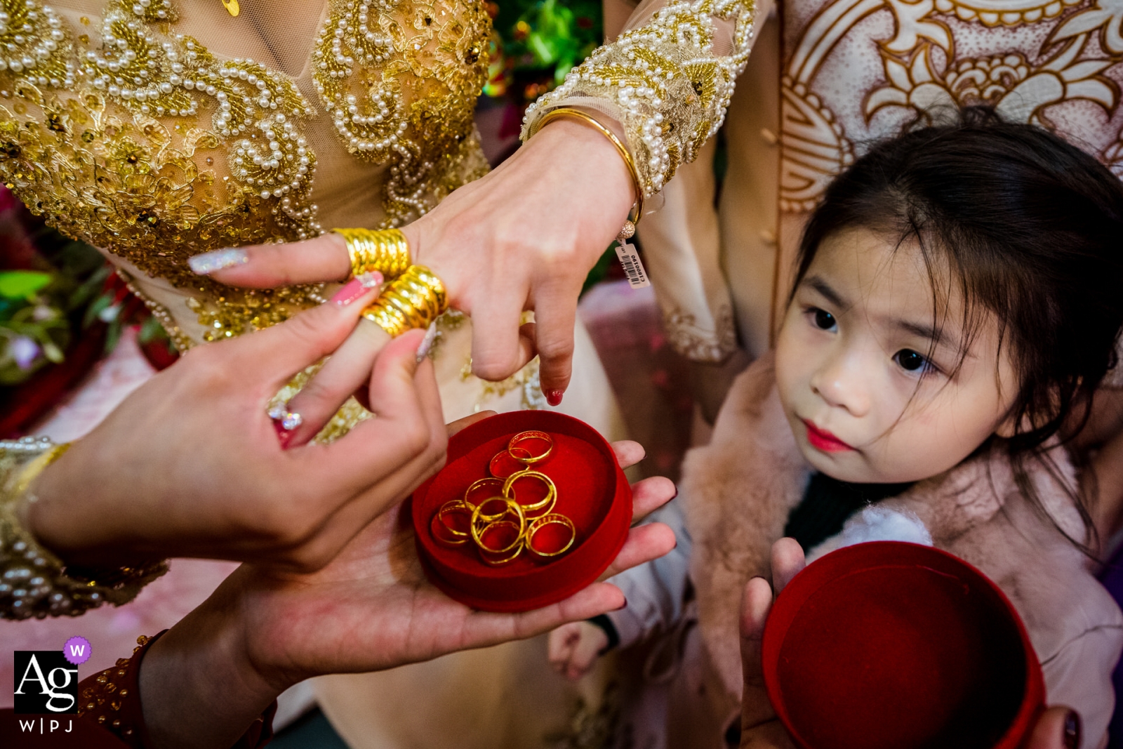 Weselna ceremonia parzenia herbaty ze złotymi pierścieniami wsuwanymi na palce panny młodej została nagrana w Ho Chi Minh City w Wietnamie z małą dziewczynką obserwującą