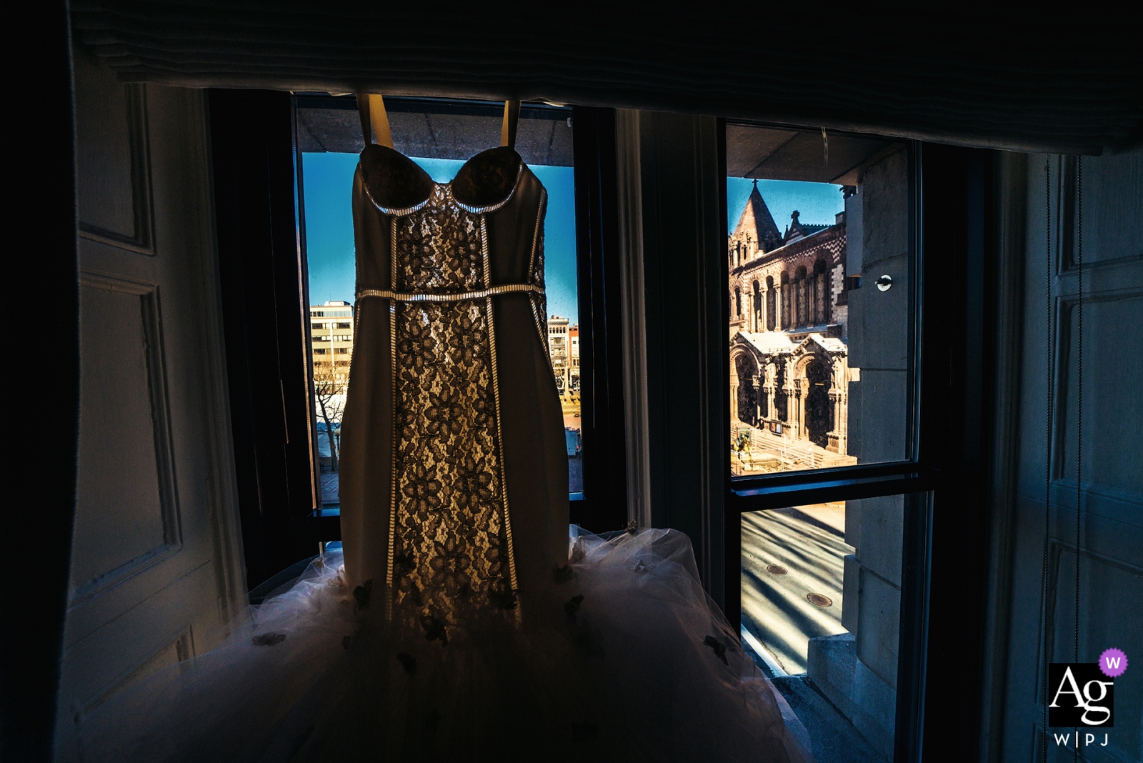 Photo by: <a href="https://www.wpja.com/photos/artistic-wedding-photographers/2443426">Wenjie Han - Long Island City New York Fairmont Copley Plaza wedding photographer | wedding dress hanging in a window before the ceremony and reception