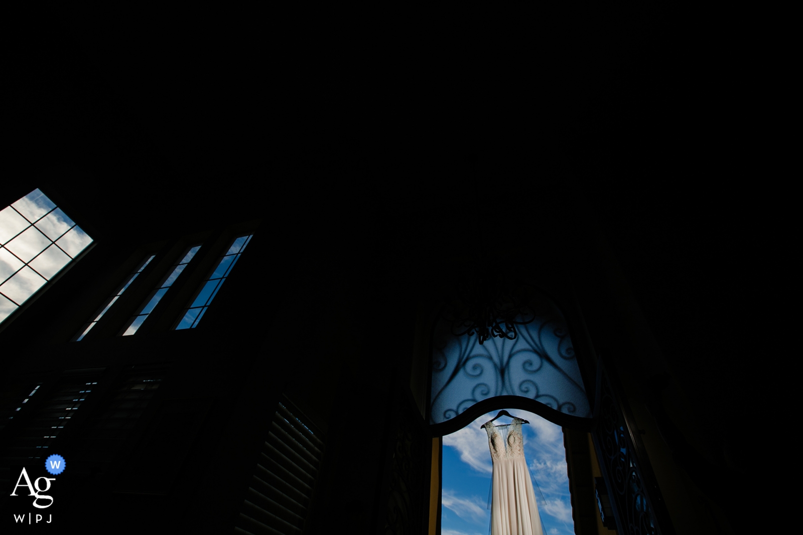 Auf einem Foto an einem Veranstaltungsort in San Francisco, Kalifornien, wurde ein Hochzeitskleid festgehalten, das in einer Fensteröffnung vor einem strahlend blauen Himmel hing