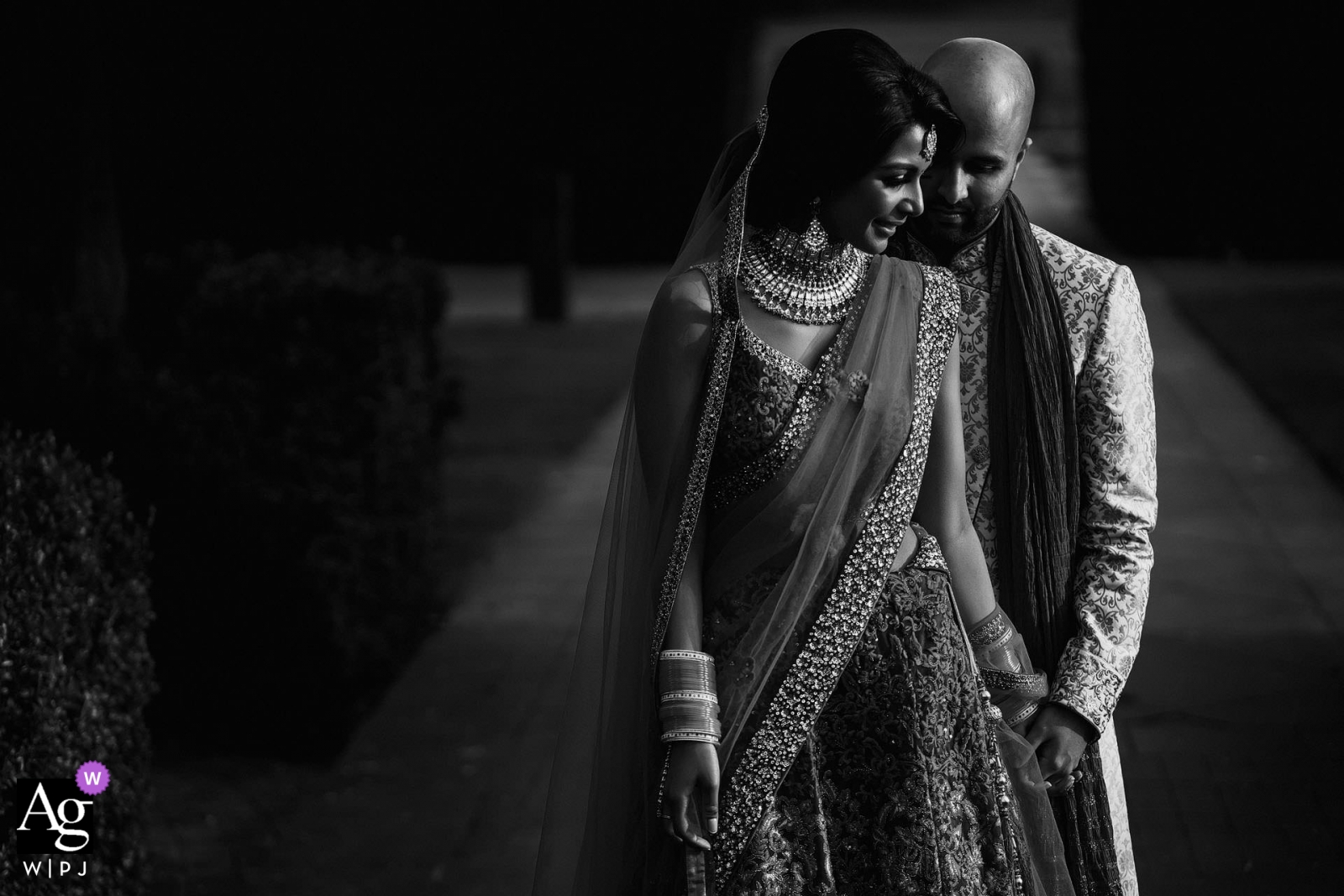 The bride and groom posed for a portrait outdoors in London, their smiling faces illuminated by harsh sunlight