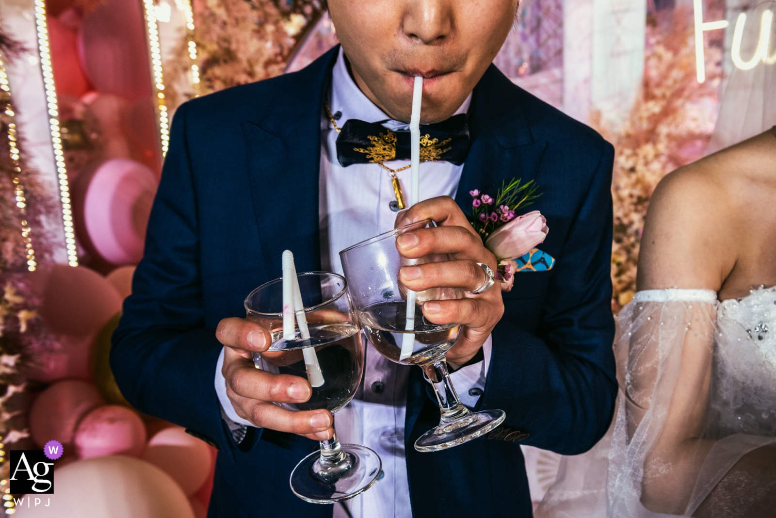 Photo by: <a href="https://www.wpja.com/photos/artistic-wedding-photographers/2448866">Jinqi Tan - Guangzhou Guangzhou wedding day photography | the groom is Drinking from a straw holding two drinks with his bride at his side