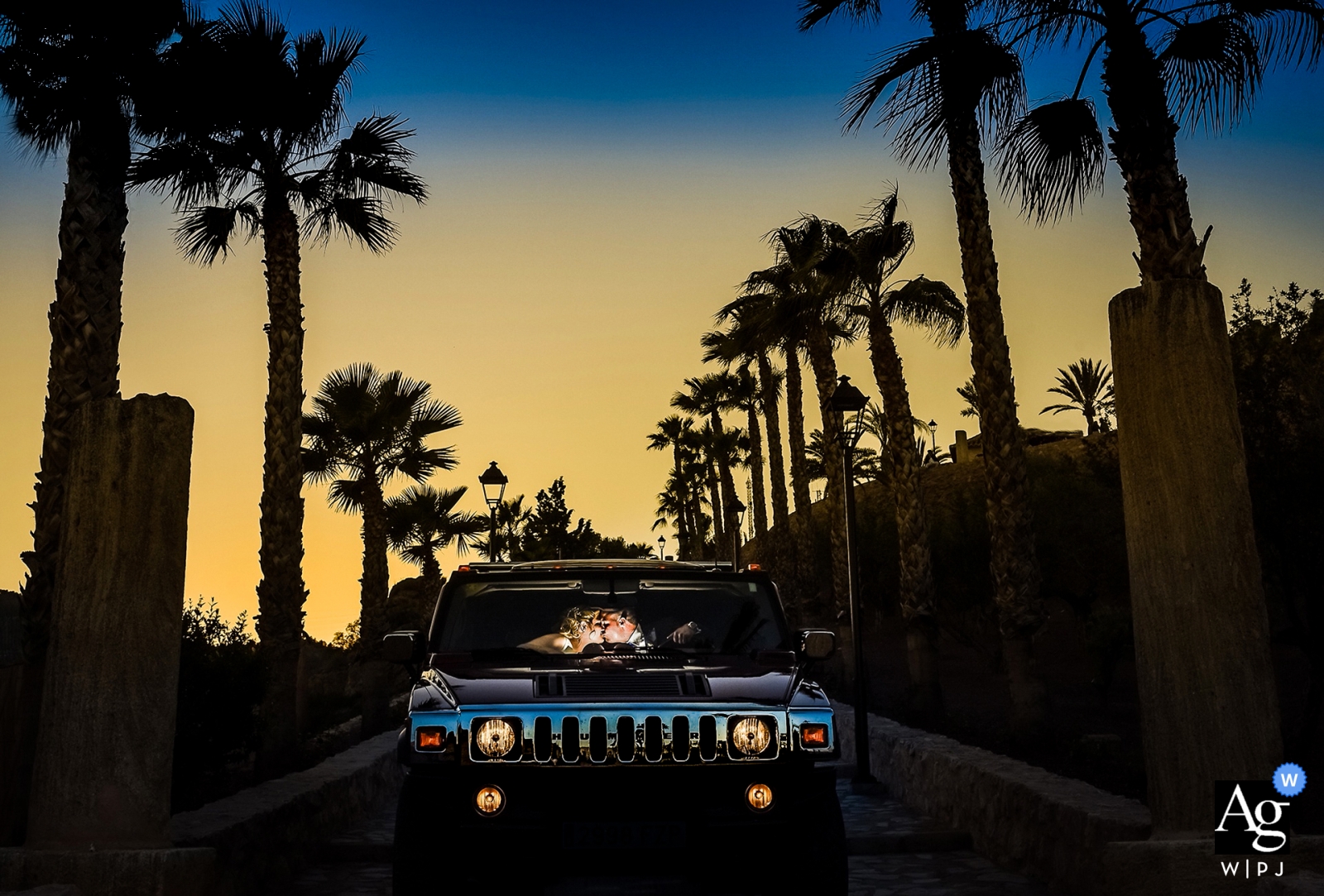 En Murcia, España, una pareja celebró su boda al atardecer en un Hummer, con la luz del atardecer cayendo sobre su paseo y altas palmeras arriba