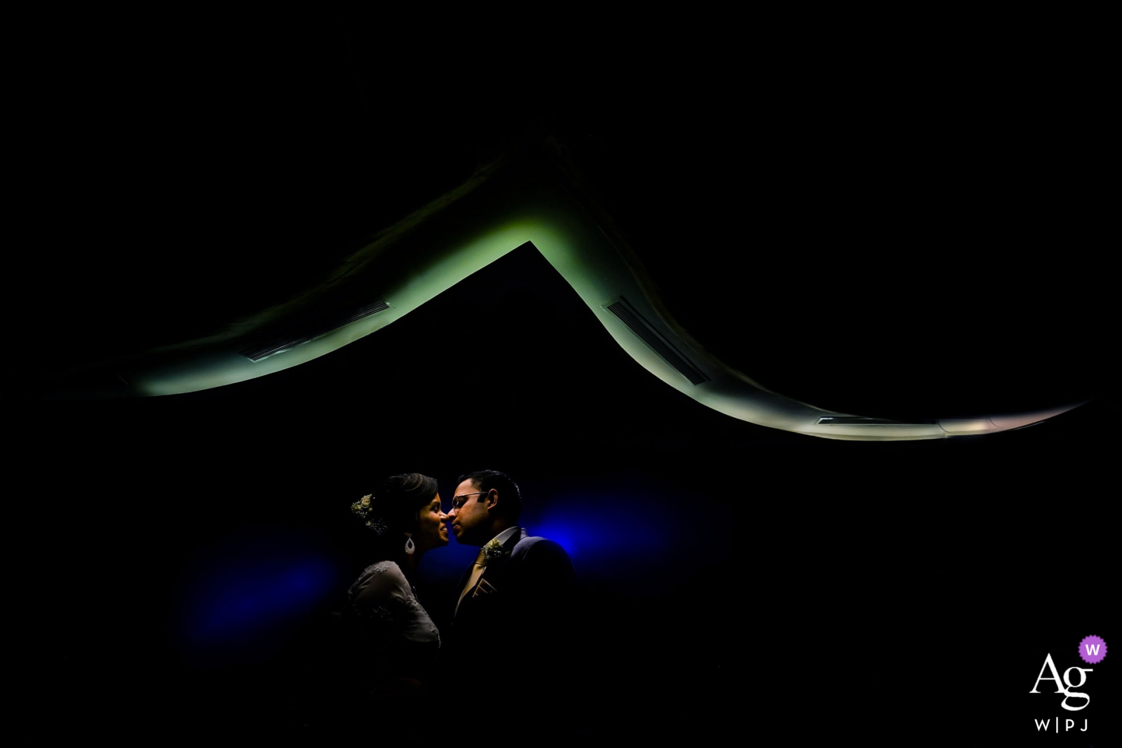 The couple happily shared a kiss in front of the soft lights of the Hilton Colombo at night at their wedding reception venue