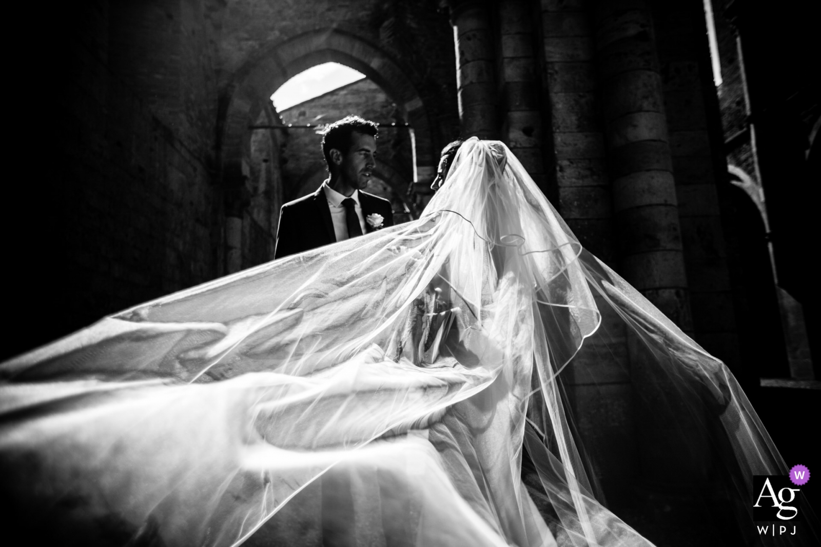 A classic black and white portrait of the bride and groom was taken at Abbey San Galgano, Italy