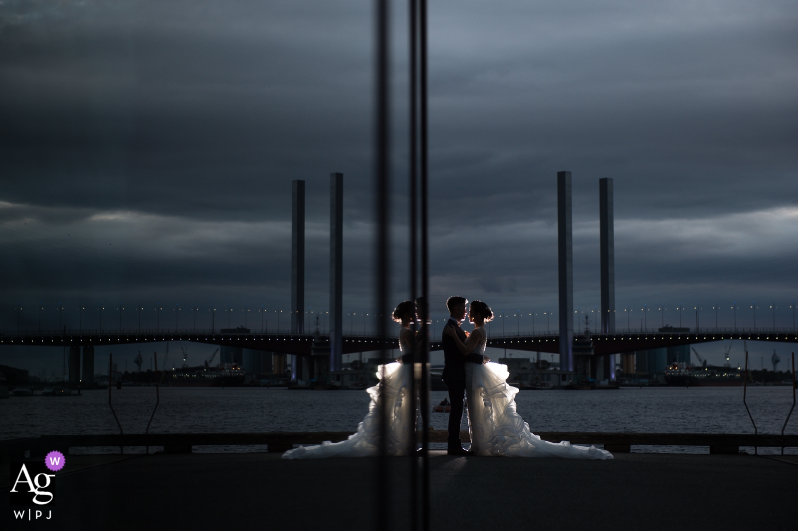 Ein Hochzeitsporträt des Paares, das sich an einem bewölkten Hochzeitstag in der Abenddämmerung in Melbourne spiegelt