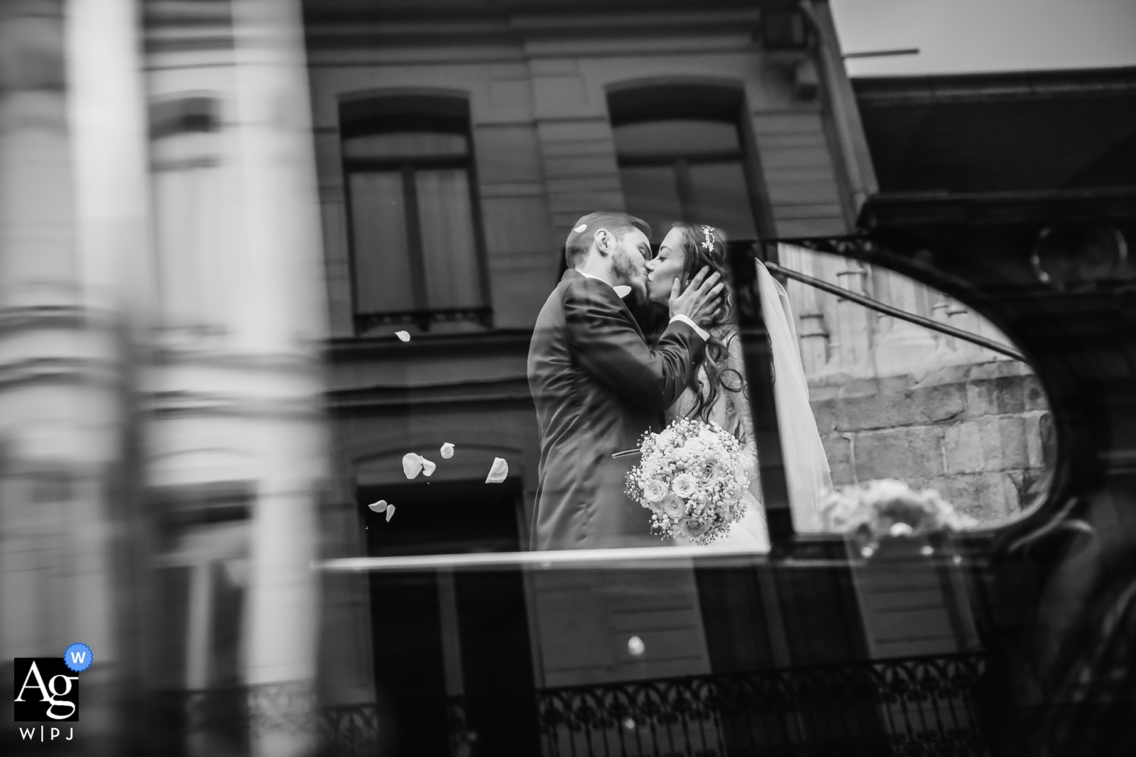 Foi tirada uma foto de uma noiva e um noivo em Paris, França, onde eles são vistos se beijando no reflexo do carro do casamento