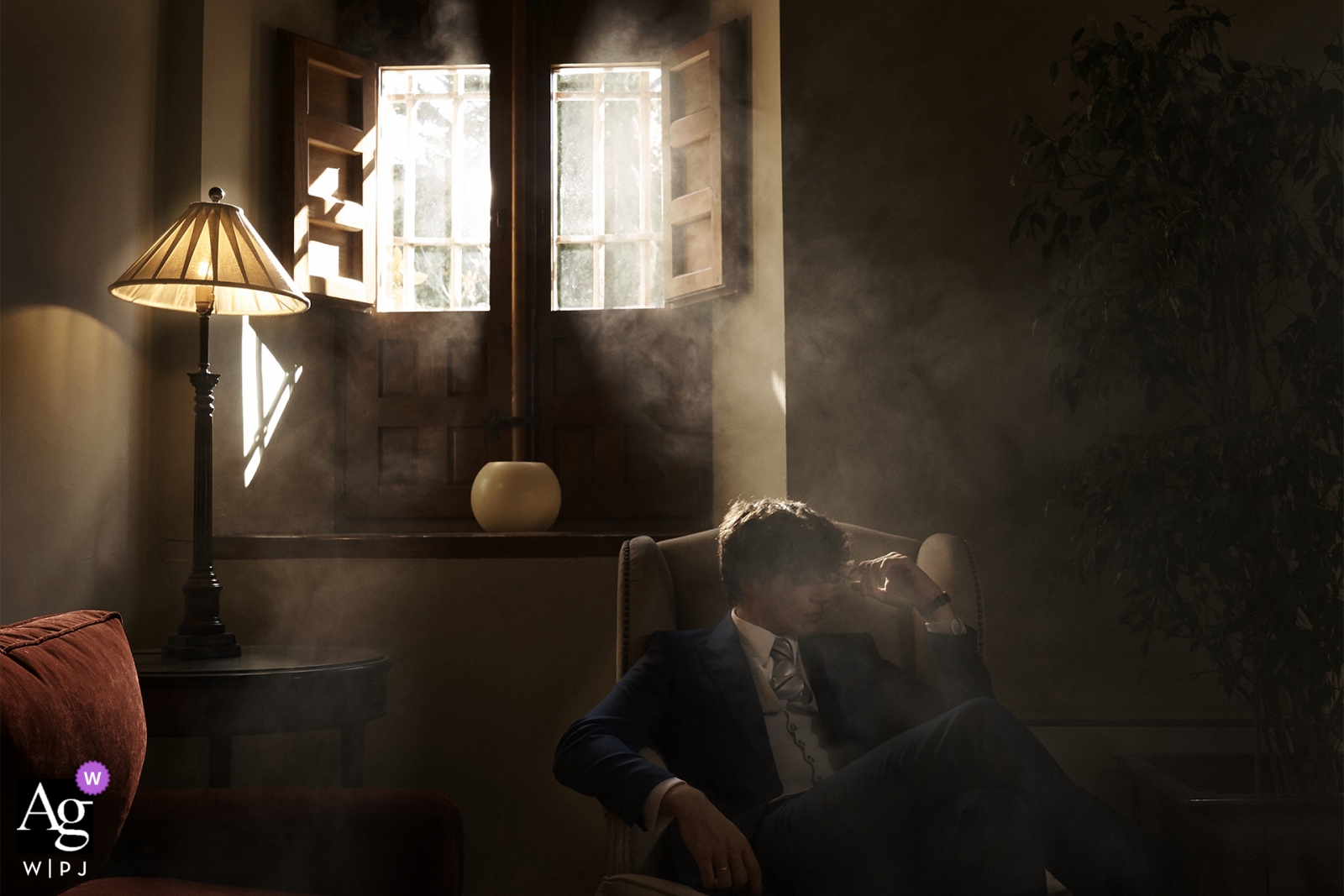 Photo by: <a href="https://www.wpja.com/photos/artistic-wedding-photographers/2461781">Jorge Miguel Jaime Baez - Canet de Berenguer Valencia Spain wedding photographer shot this portrait of the groom as he sits in a dark, smoky room before his Valencia wedding