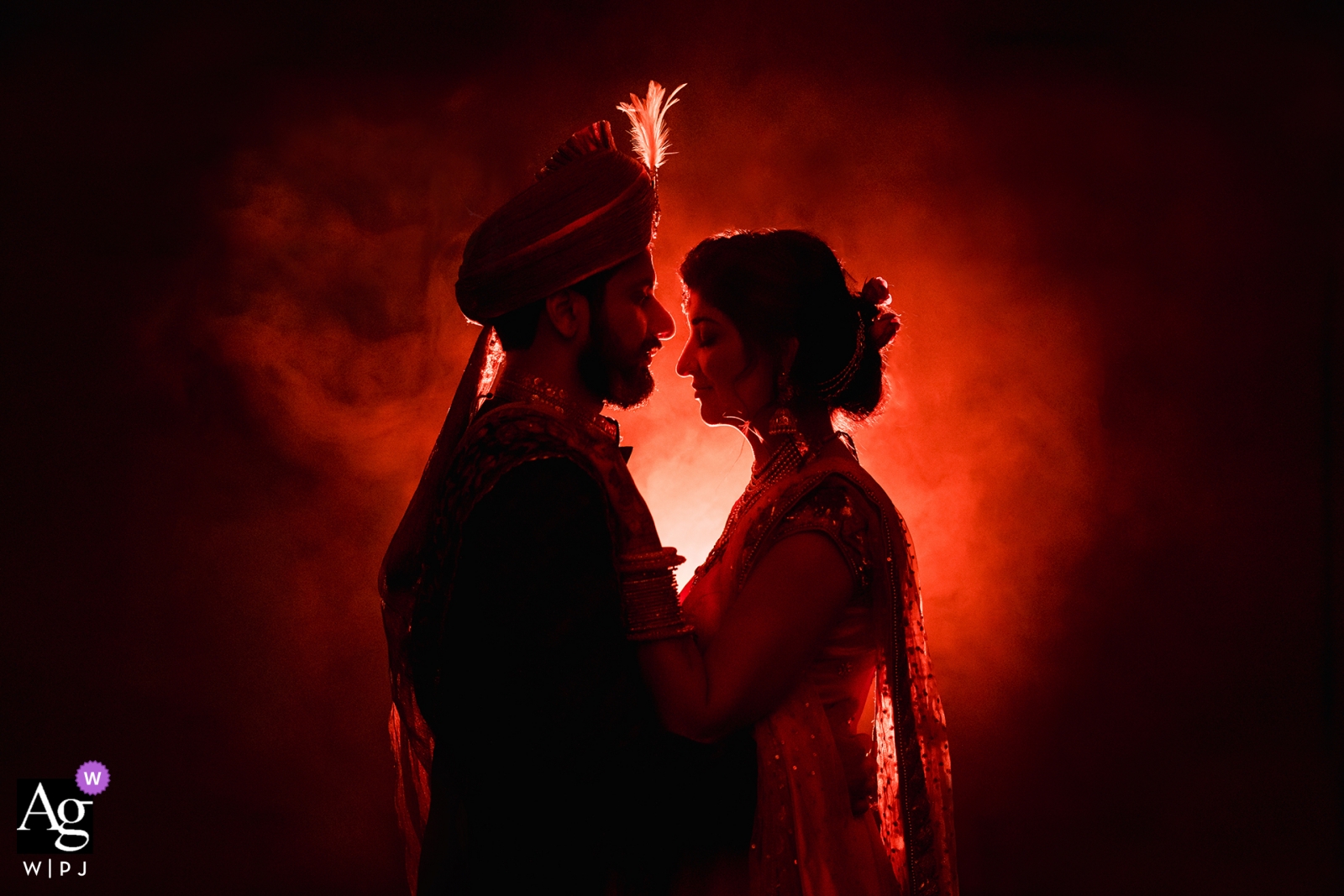 Mariée et marié de Californie dans une silhouette avec un fond clair rouge