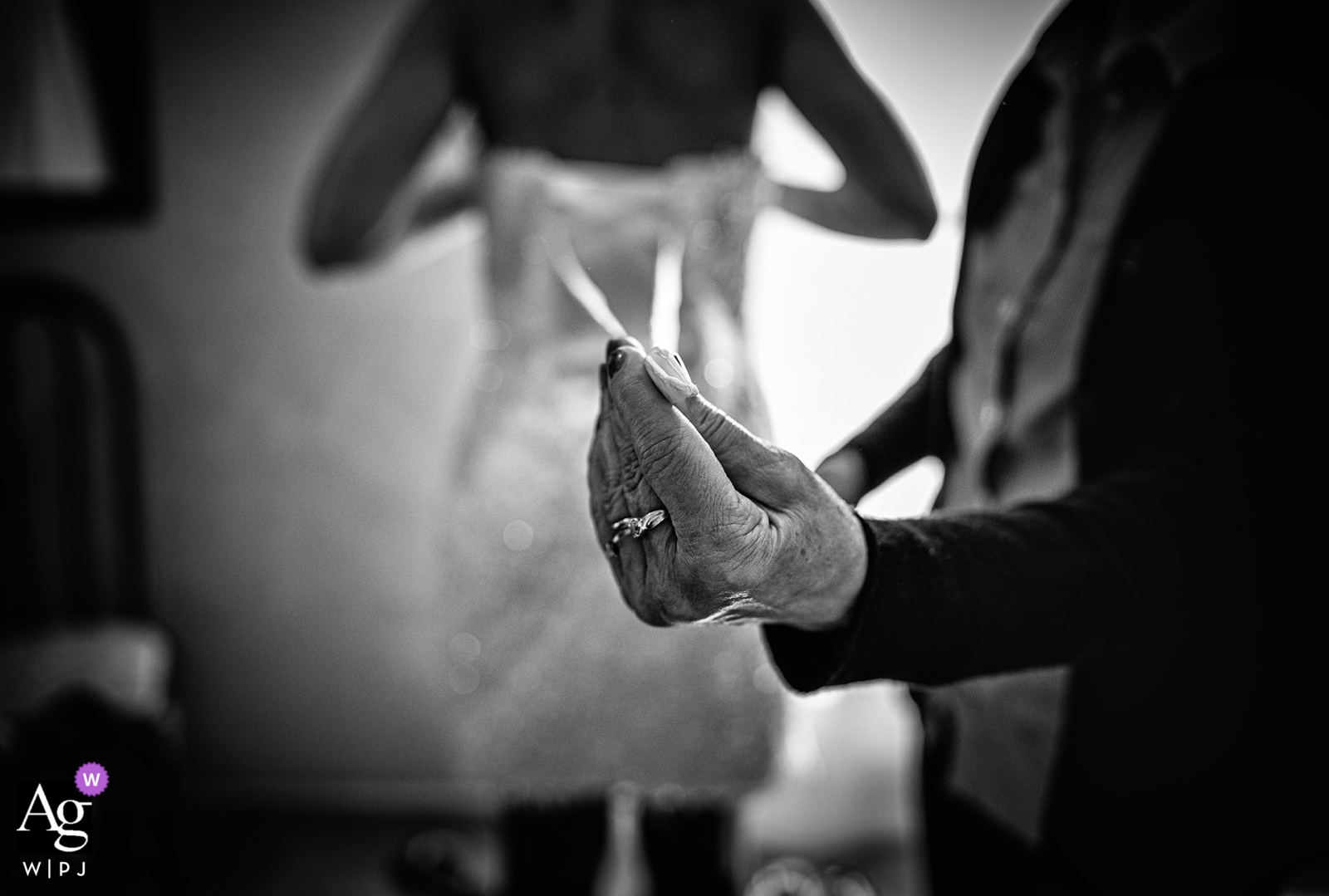 Una imagen de boda en blanco y negro que muestra el vestido de novia sostenido por una mano amiga en el club Cuccaro captura los preparativos para el día especial