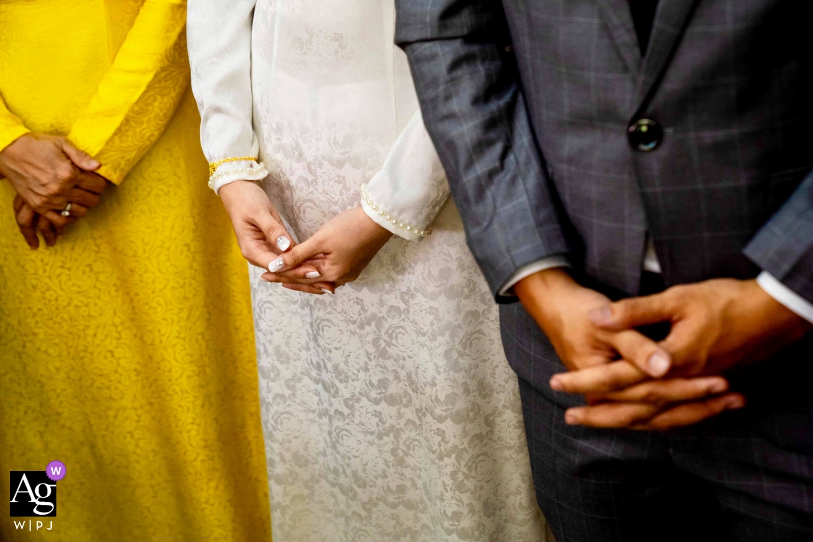 Cette photographie capture deux femmes et un homme vêtus d'une tenue de mariage traditionnelle vietnamienne attendant de commencer la cérémonie de mariage à Ho Chi Minh-Ville