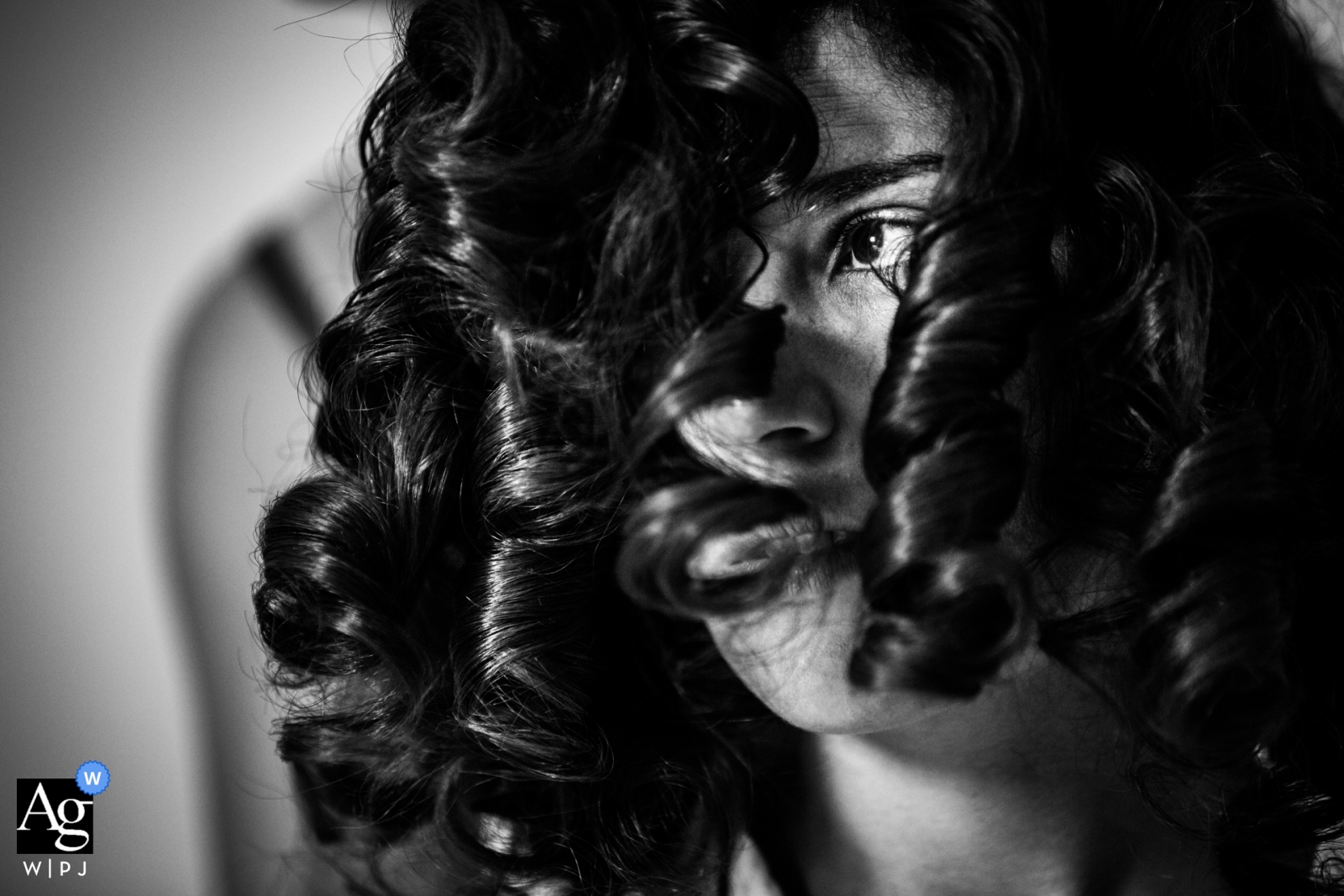 Esta foto de boda de Algámitas, Sevilla, Andalucía (España) captura el cabello rizado de la novia en detalle, con su ojo asomándose por debajo de sus mechones oscuros.