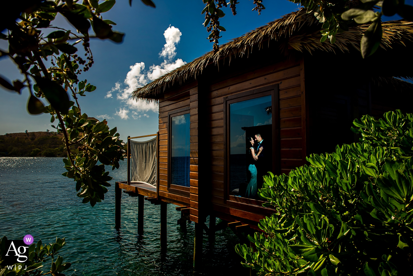 La novia y el novio posaron para un retrato en Sandals Grande St. Lucian en un bungalow sobre el agua