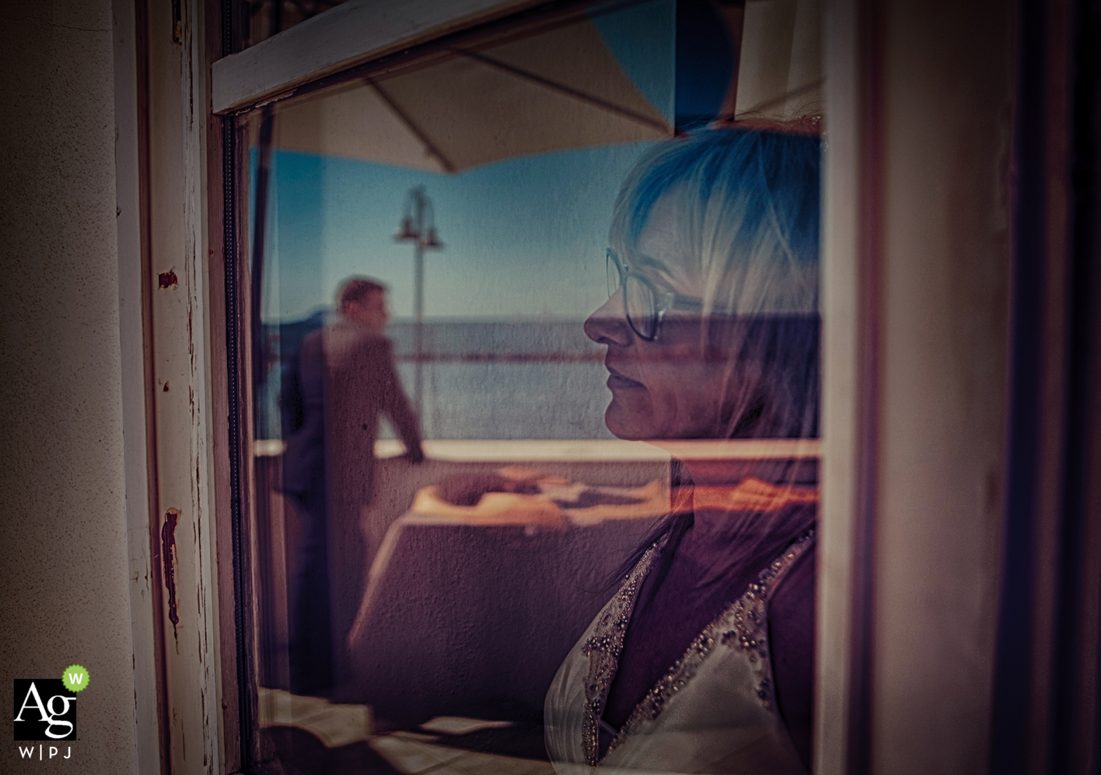 A photograph of a groom in Lerici, Italy, is reflected in a glass window on his wedding day