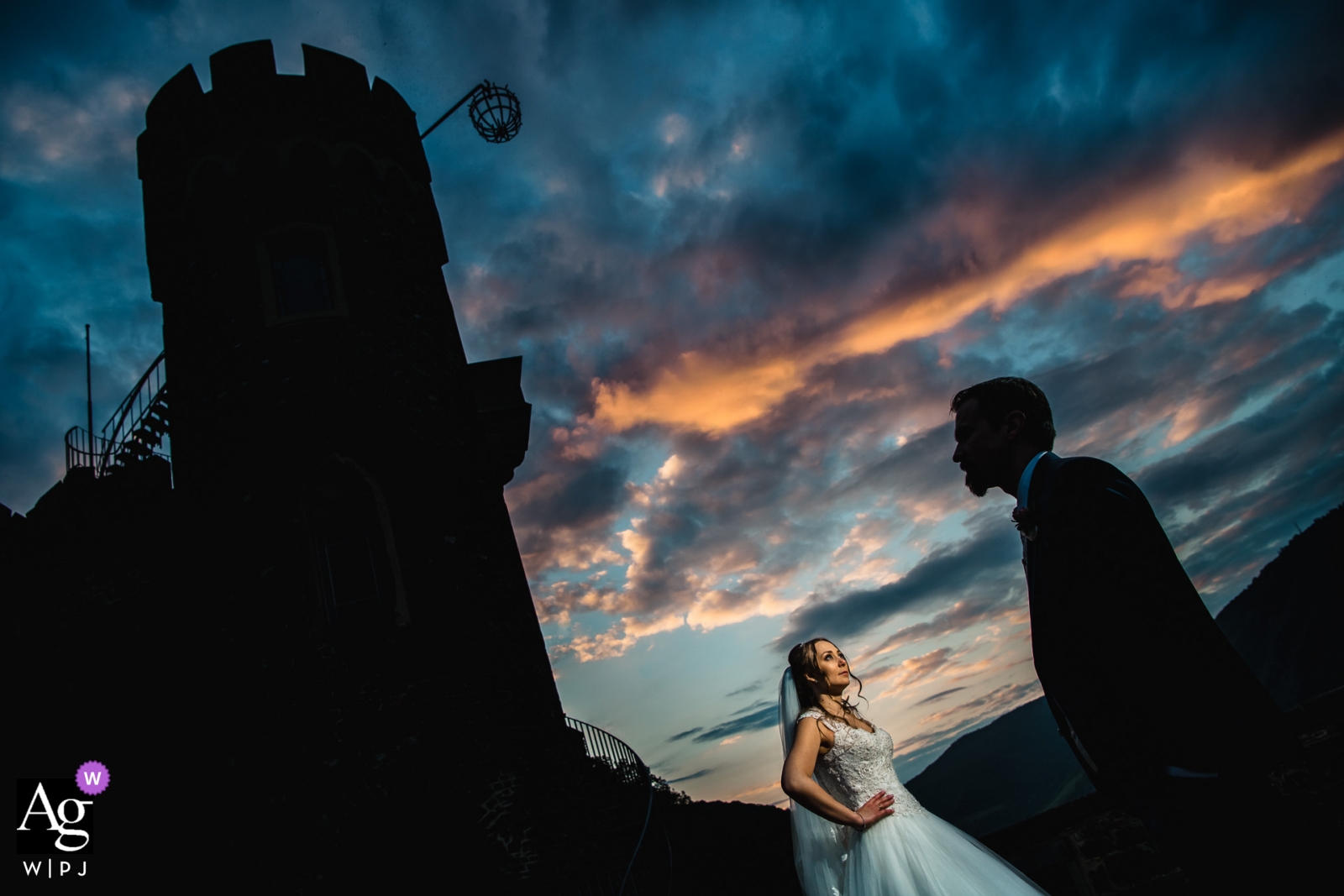 Der bewölkte Himmel auf der Burg Rheinstein erzeugte einen wunderschönen Kontrast aus Licht und Schatten, wobei die Silhouette des Bräutigams im Vordergrund zu sehen war und die Braut im Licht in der Nähe der Burg stand