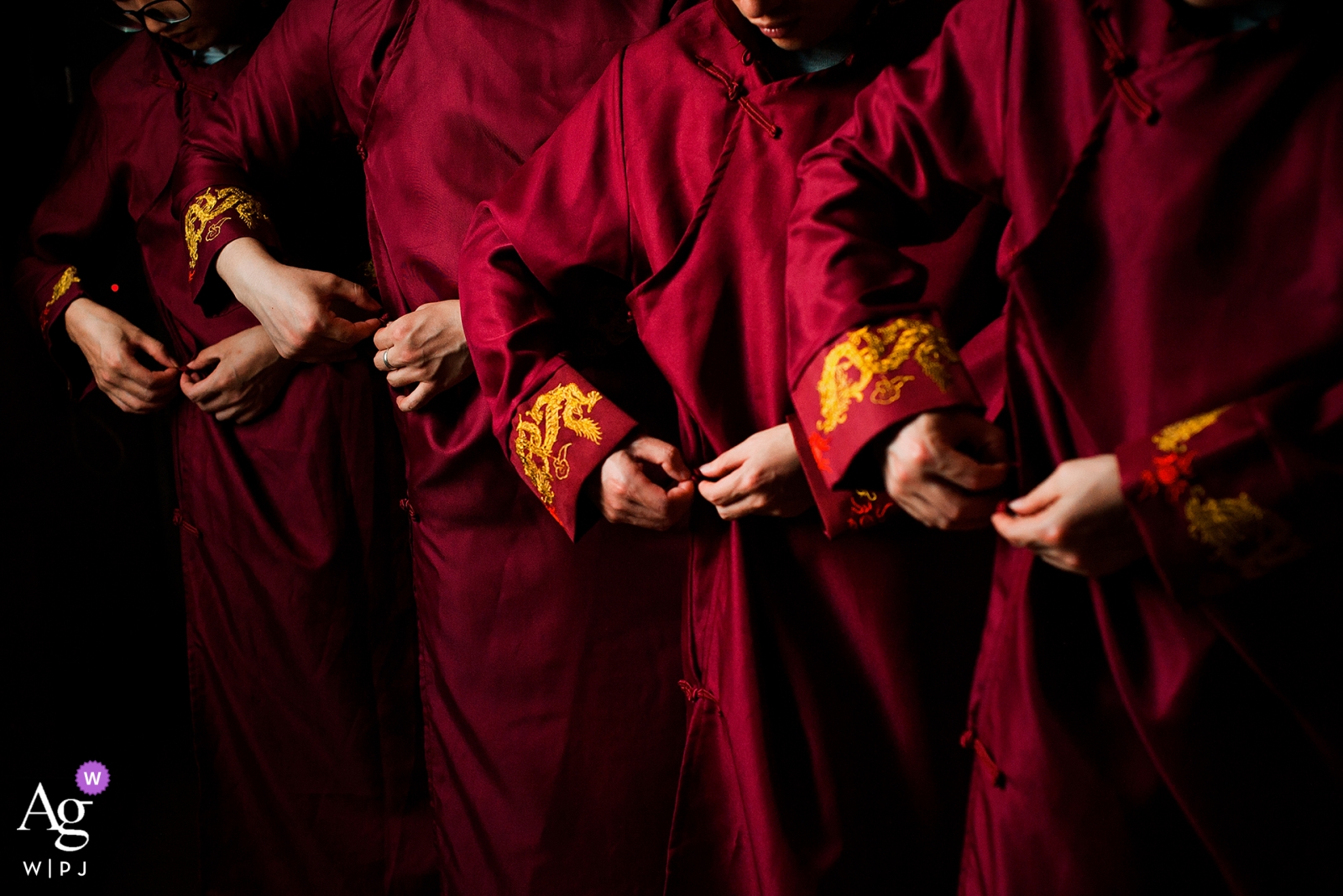 Zdjęcie: <a href="https://www.wpja.com/photos/artistic-wedding-photographers/2527151"> Xiang Liu - Nanping Fotograf ślubny Nanping stworzył ten obraz rąk drużbów wiążących szaty przed ceremonią