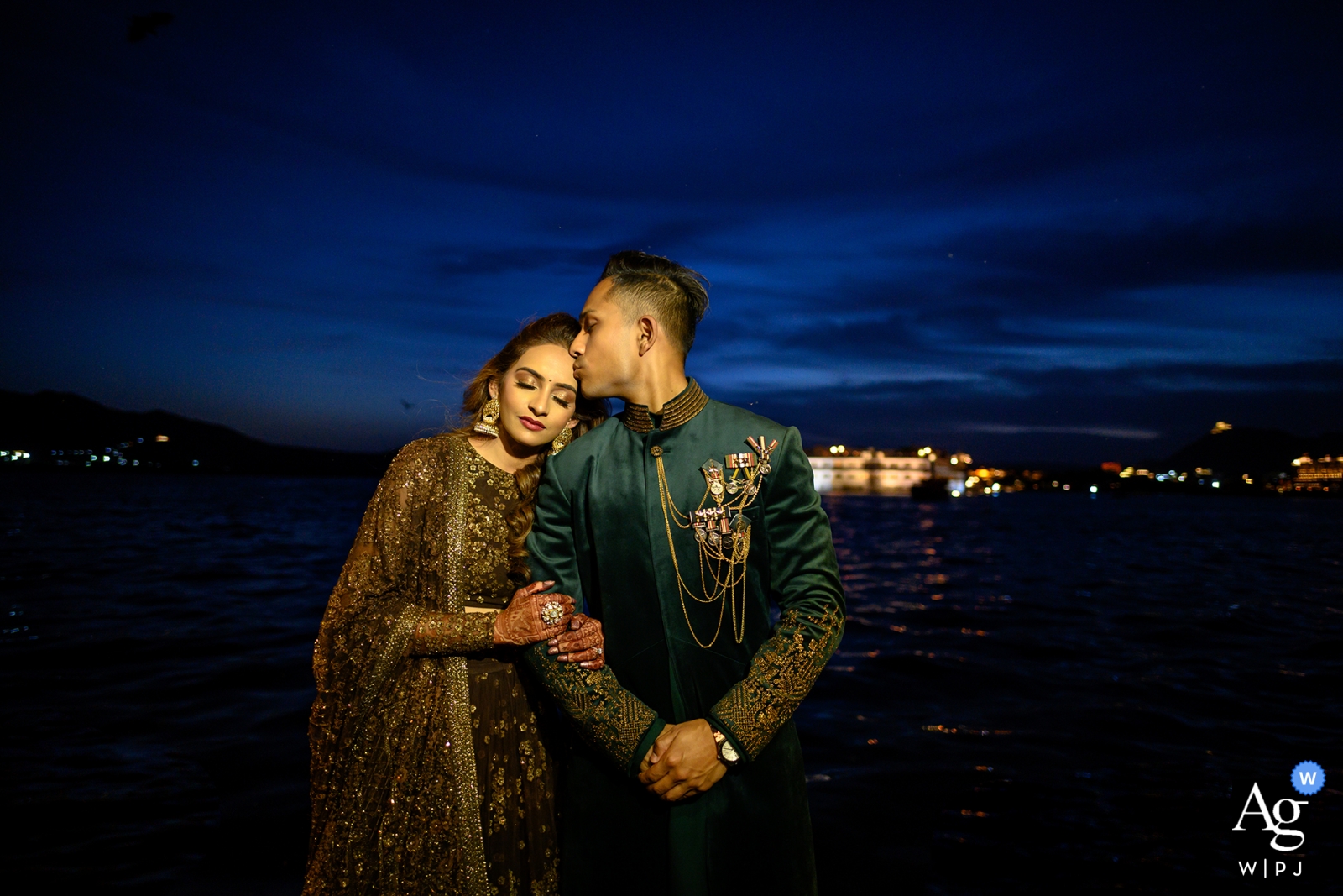 La hermosa boda en Udaipur, India, estuvo llena de amor cuando la pareja compartió un romántico retrato nocturno y un dulce beso en la frente.