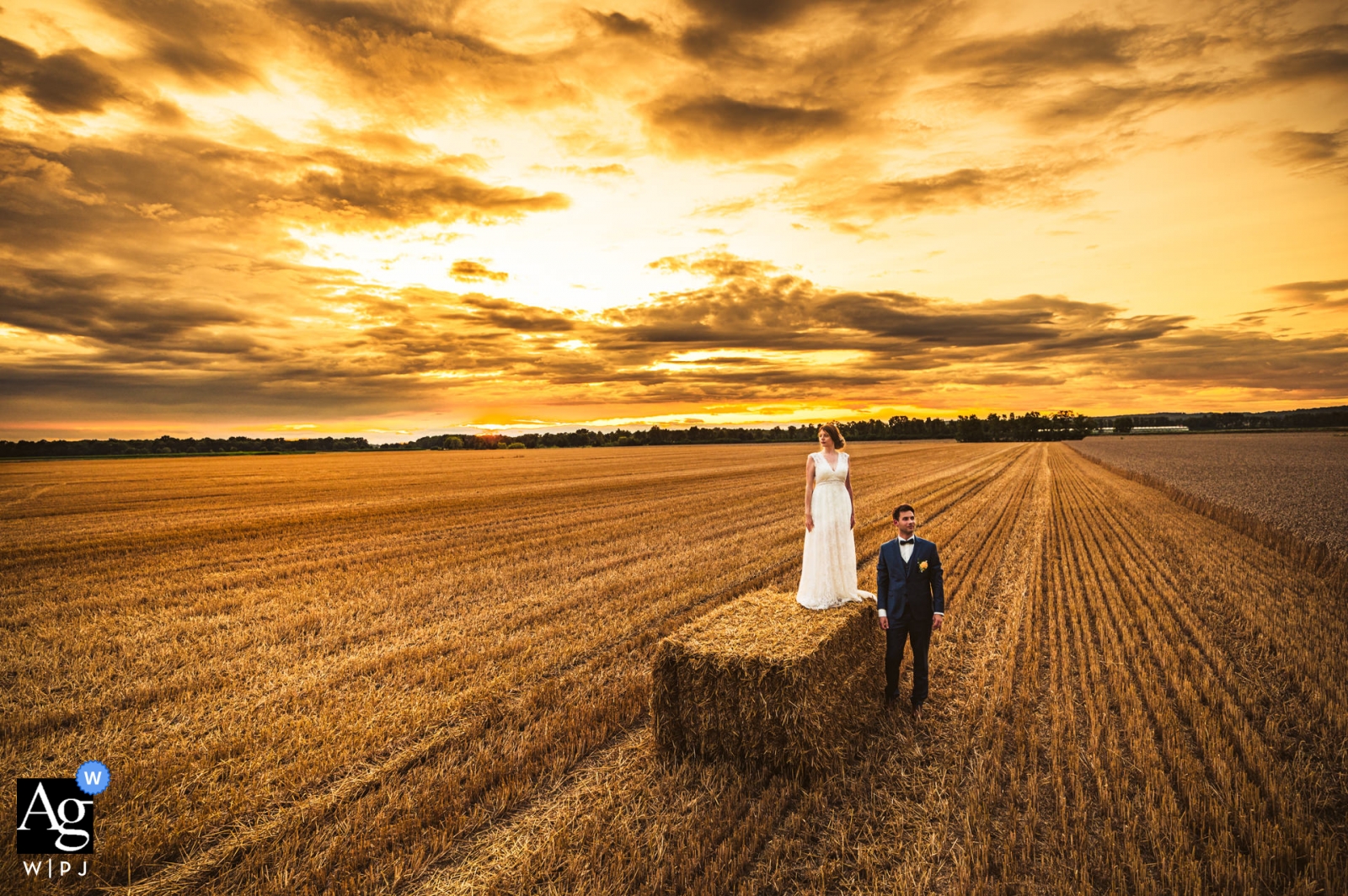 The bride and groom stood in the beautiful Toplice, Slovenia, surrounded by a freshly cut field