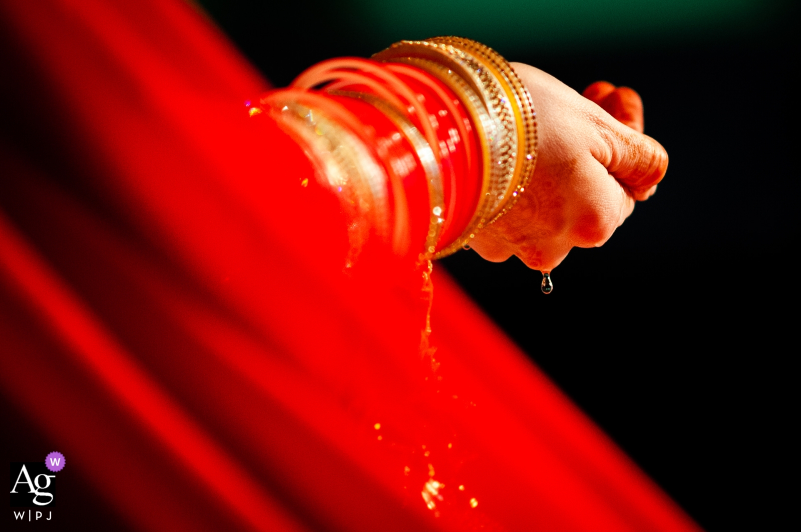 Photo by: <a href="https://www.wpja.com/photos/artistic-wedding-photographers/2528906">Emil Boczek - Wolverhampton West Midlands London wedding photographer shot this detail photo of water dripping off the brides hands and bangled covered wrists