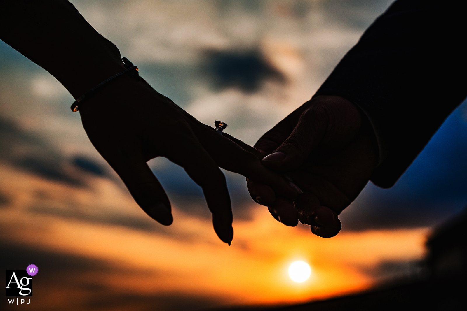 Dettaglio di nozze di Liberty State Park di un tramonto e le mani profilate della sposa e dello sposo