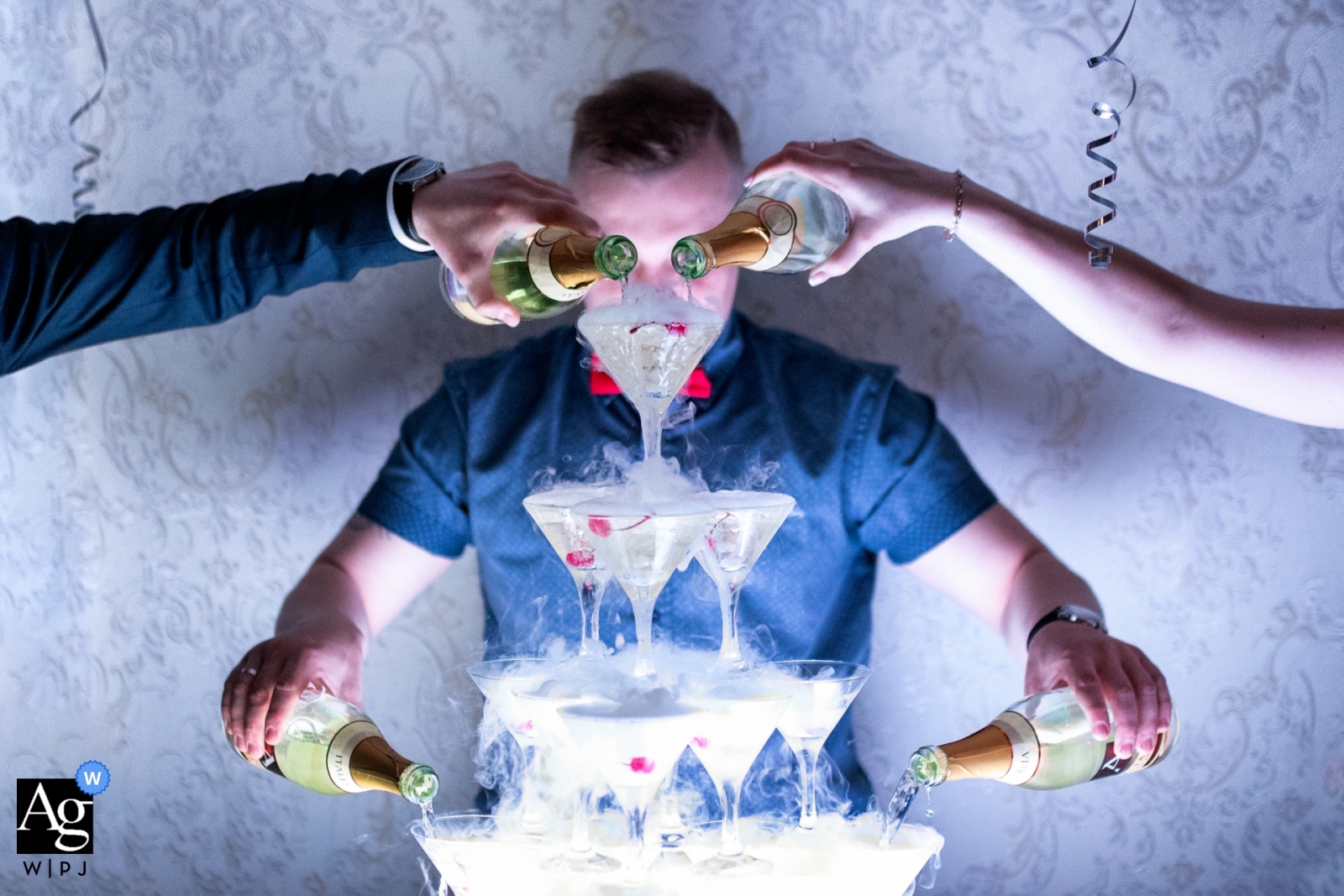 Wedding day detail of a champagne slide with multiple hands pouring during this Russia wedding