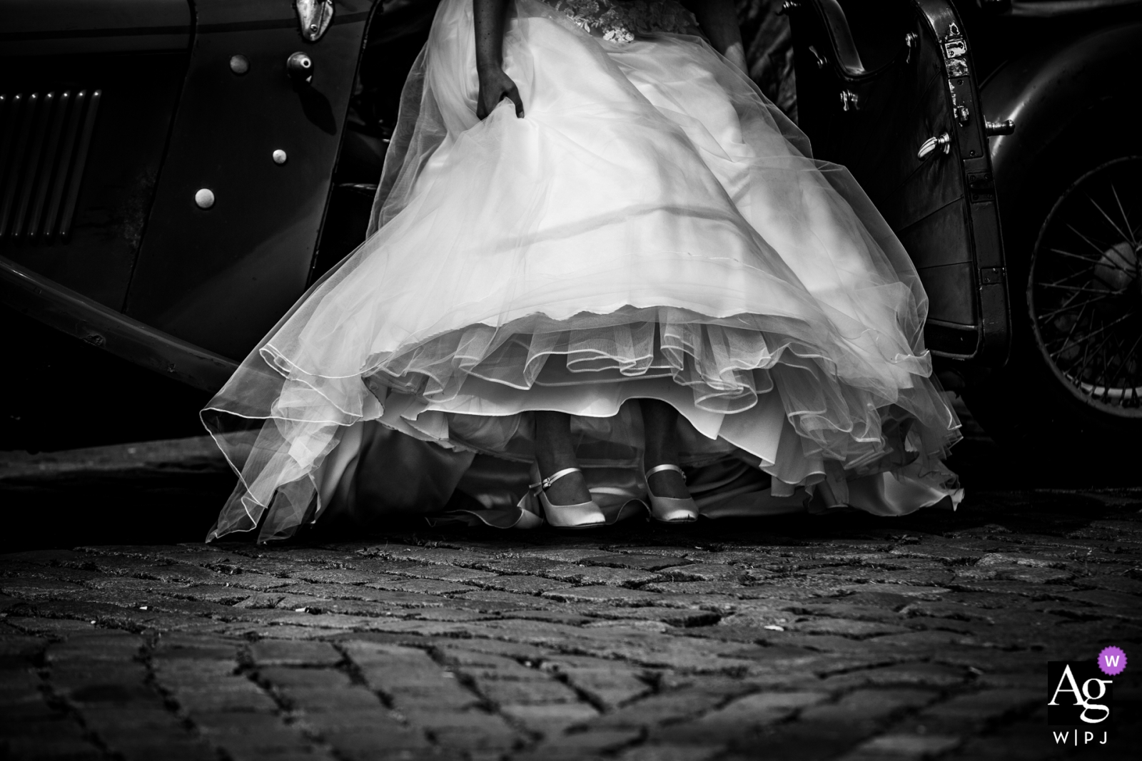 Netherlands wedding detail of the bride's dress while she gets into a car