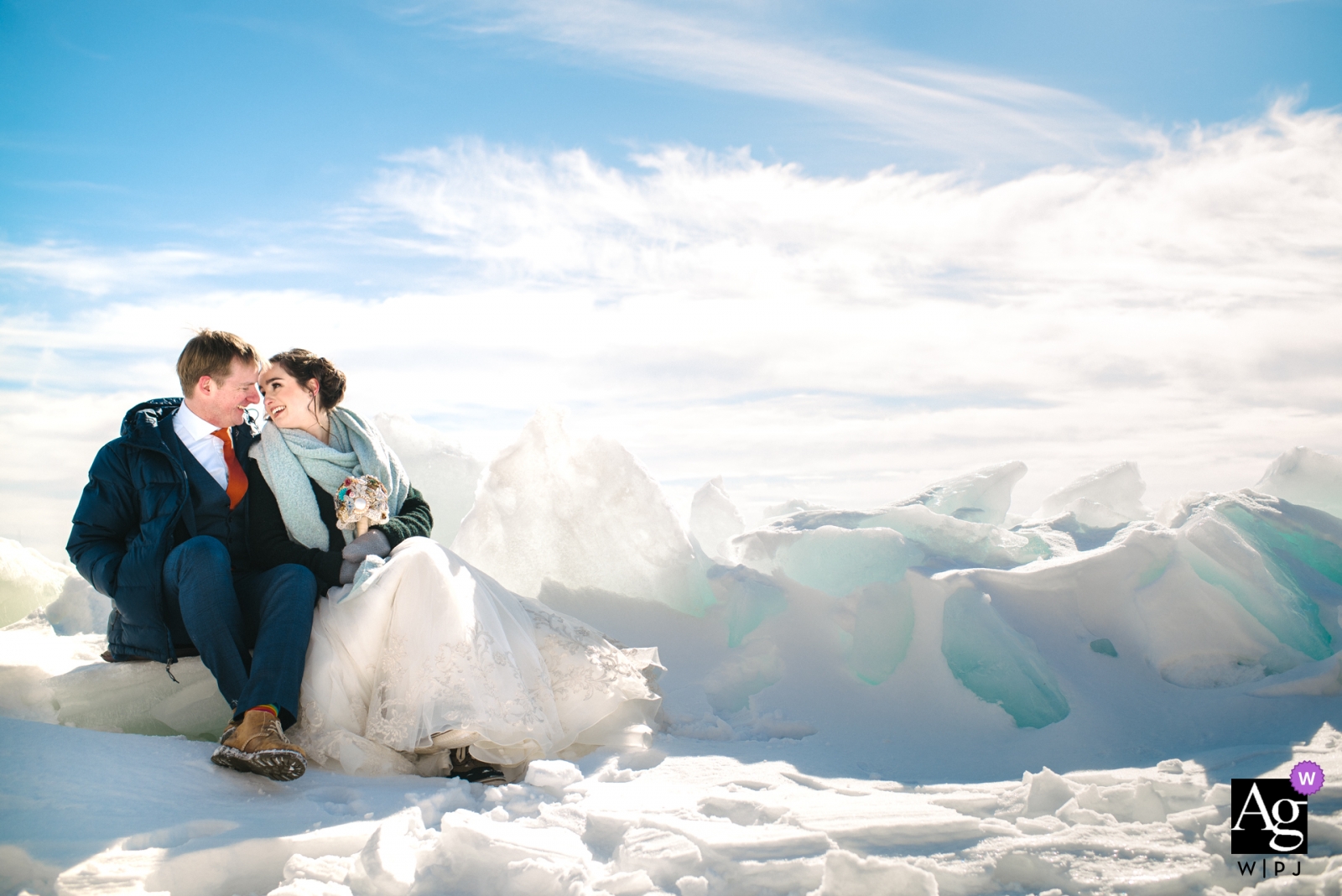 Braut und Bräutigam ruhen sich für ein Hochzeitsporträt am eisigen Ufer des Ontariosees aus