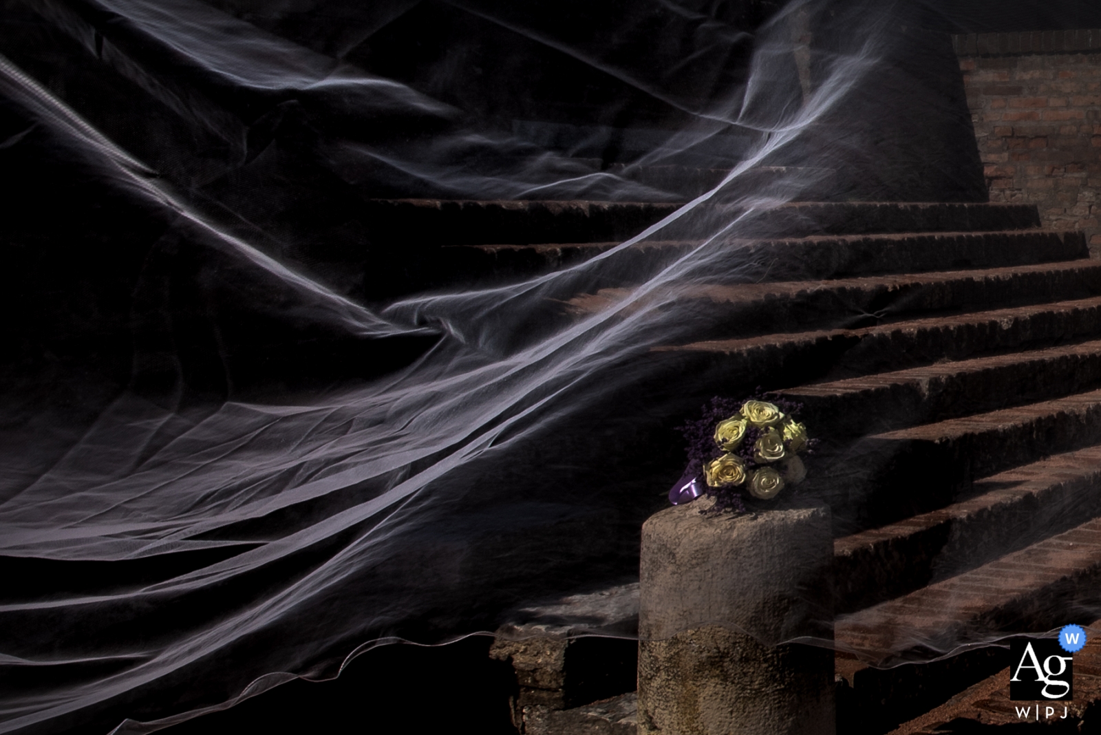 Image de détail de mariage du bouquet et du voile de la mariée un jour de vent au Castello di San Giorgio